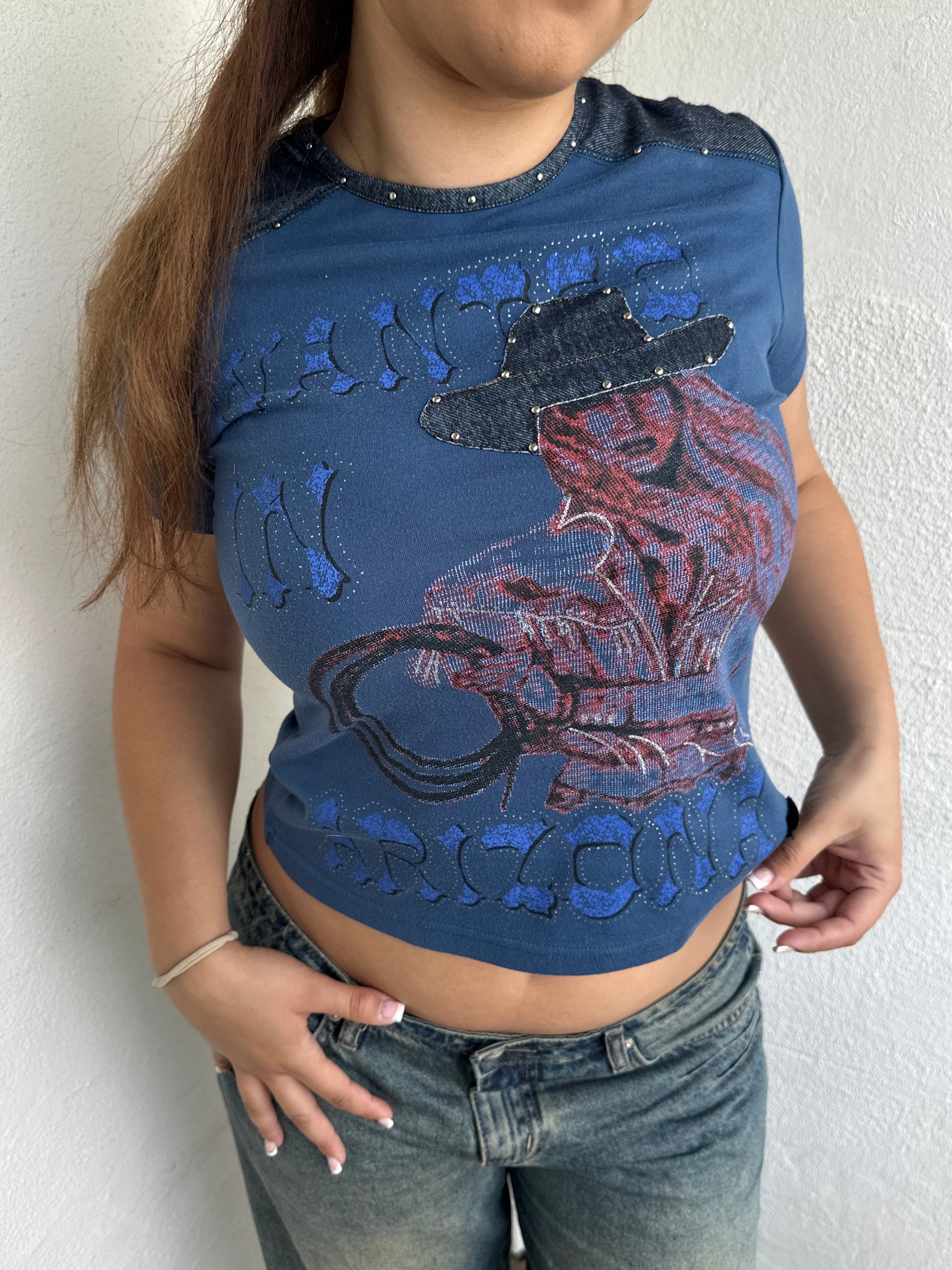 Woman Dressed in Y2K 00s Designer Just Cavalli cowgirl t-shirt featuring a woman cowgirl graphic print with western-style text. 