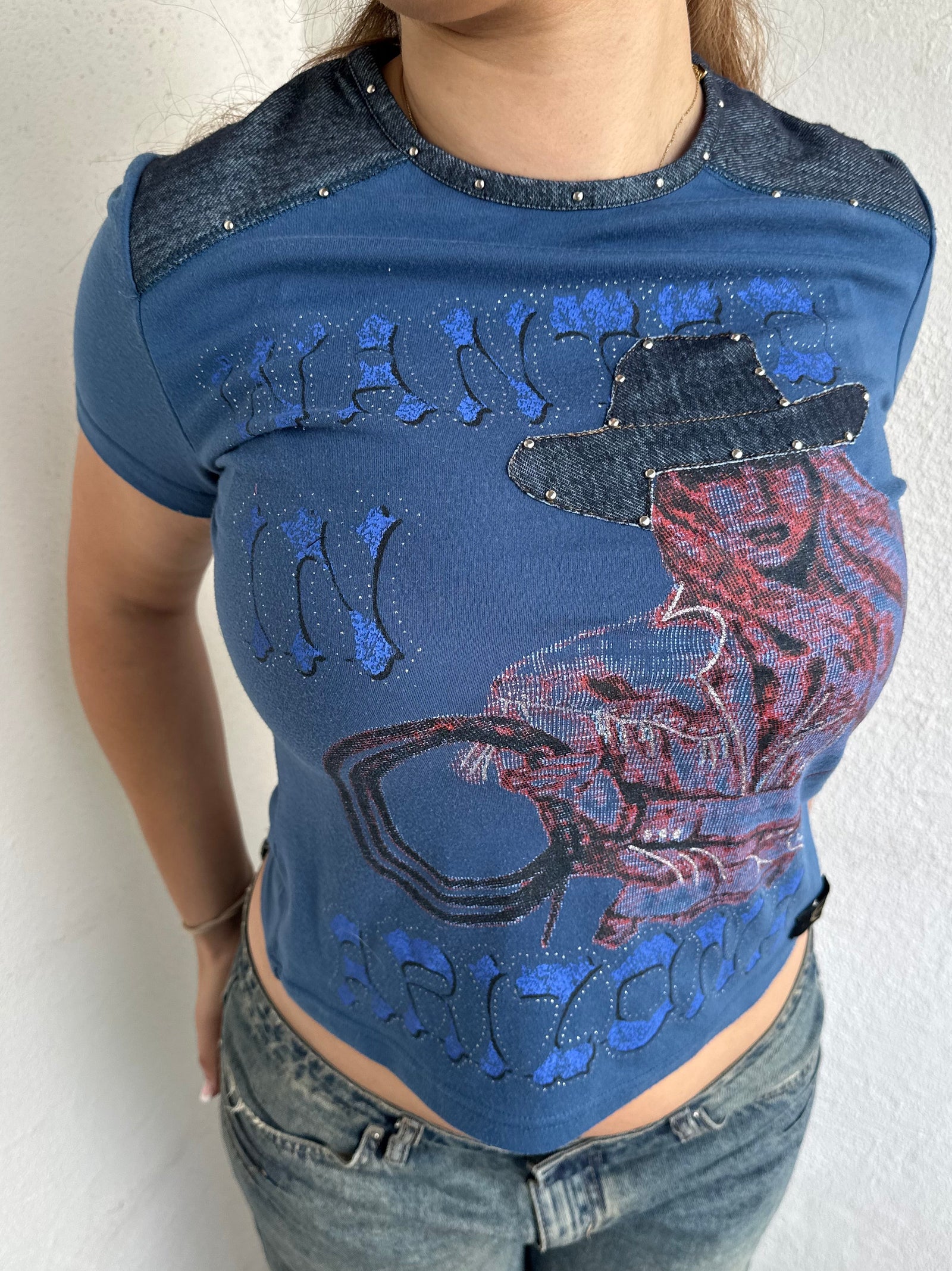 Woman Dressed in Y2K 00s Designer Just Cavalli cowgirl t-shirt featuring a woman cowgirl graphic print with western-style text. 