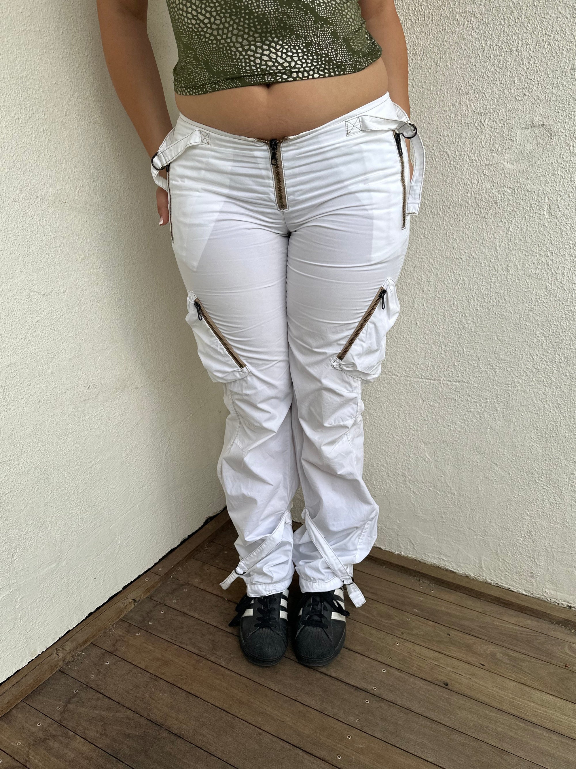 Woman Dressed in Y2K 00s white low-rise cargo pants, classic cargo pocket detailing and strap details.