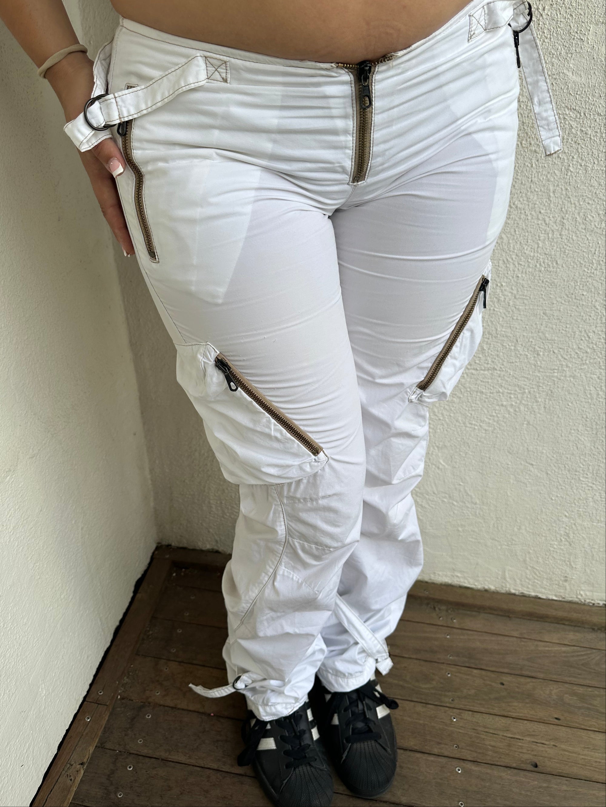 Woman Dressed in Y2K 00s white low-rise cargo pants, classic cargo pocket detailing and strap details.