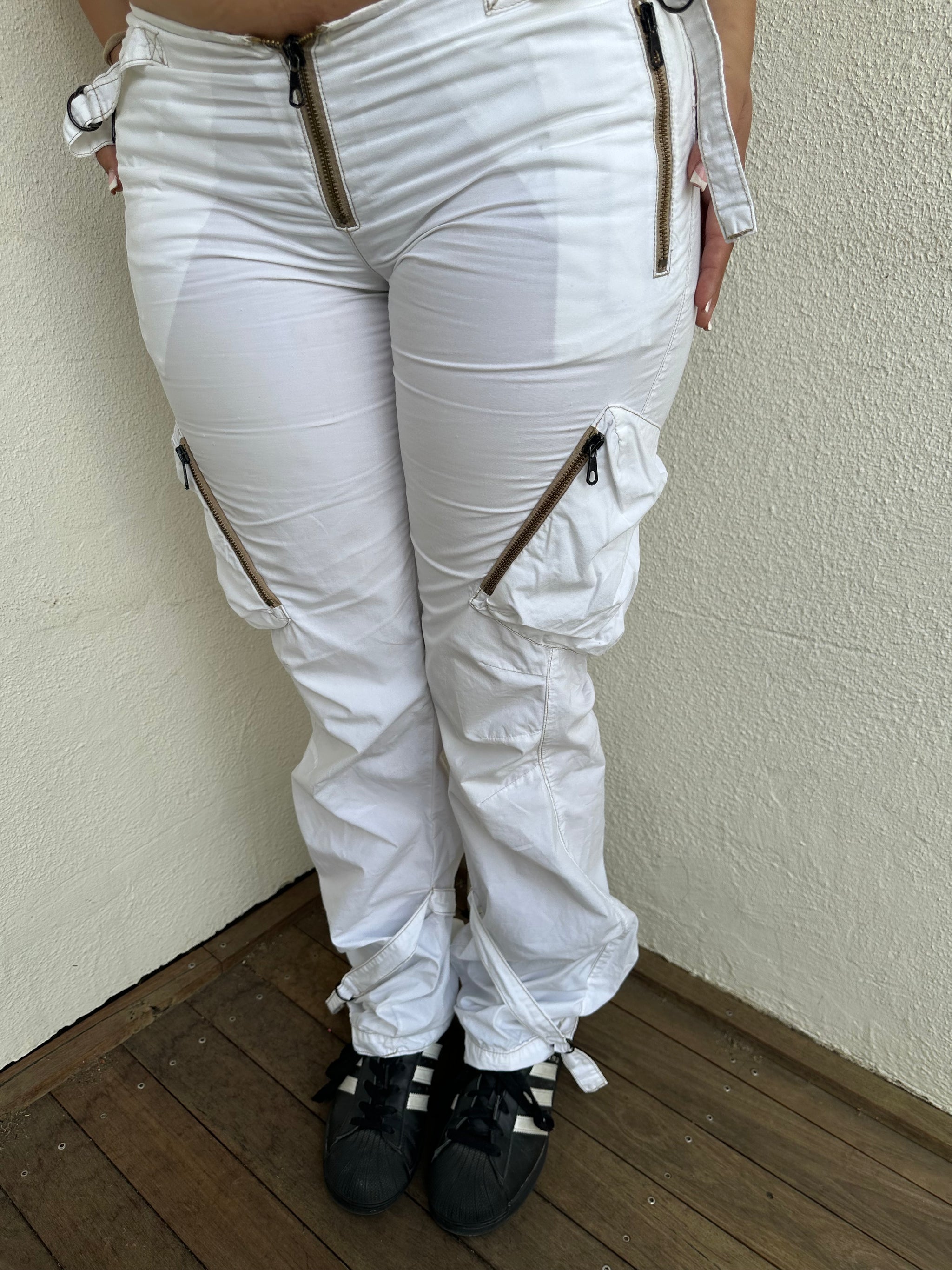 Woman Dressed in Y2K 00s white low-rise cargo pants, classic cargo pocket detailing and strap details.