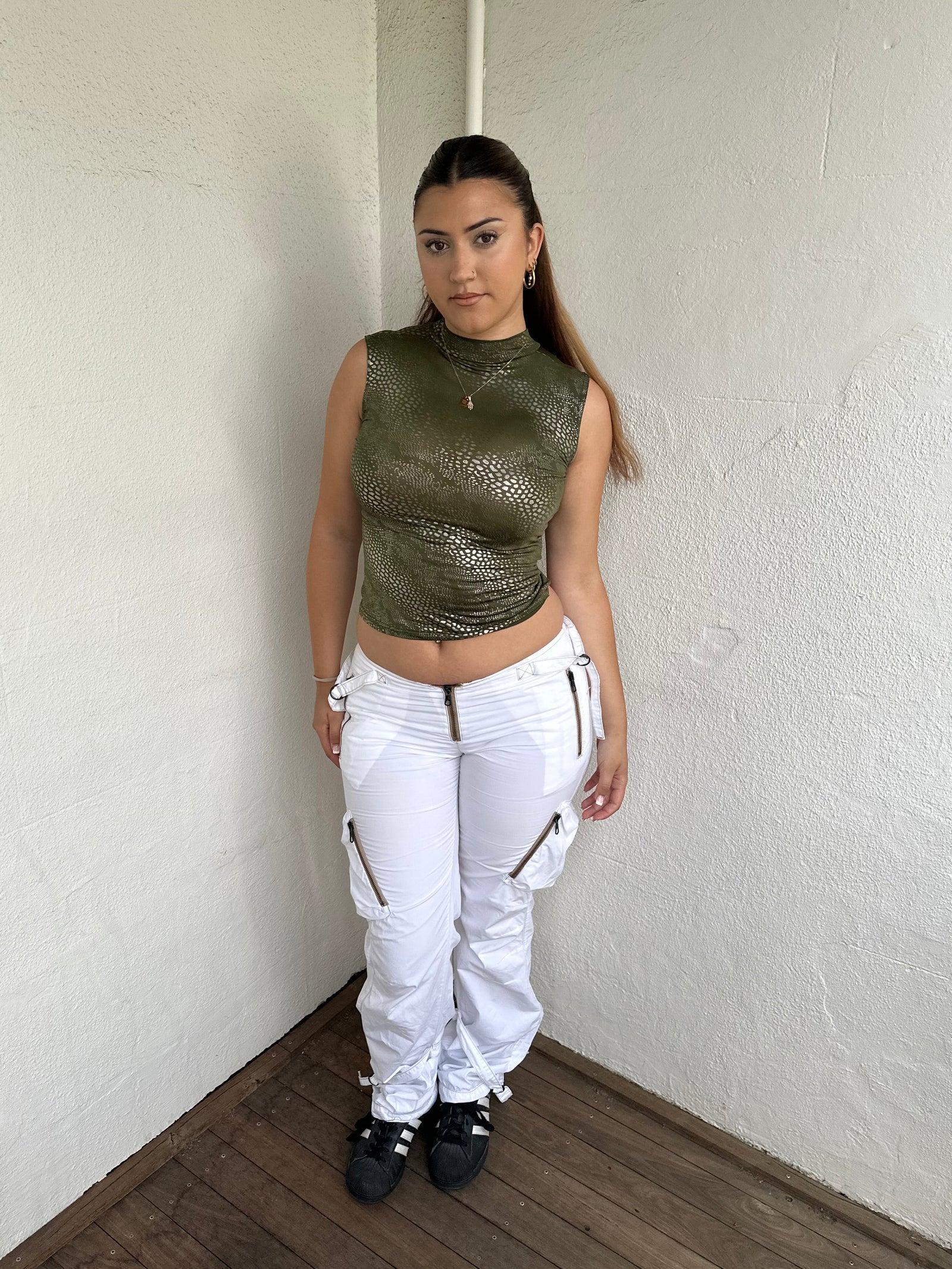 Woman Dressed in Y2K 00s white low-rise cargo pants, classic cargo pocket detailing and strap details.