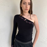 Woman wearing a Y2K 00s black one shoulder one sleeve with purple floral print 