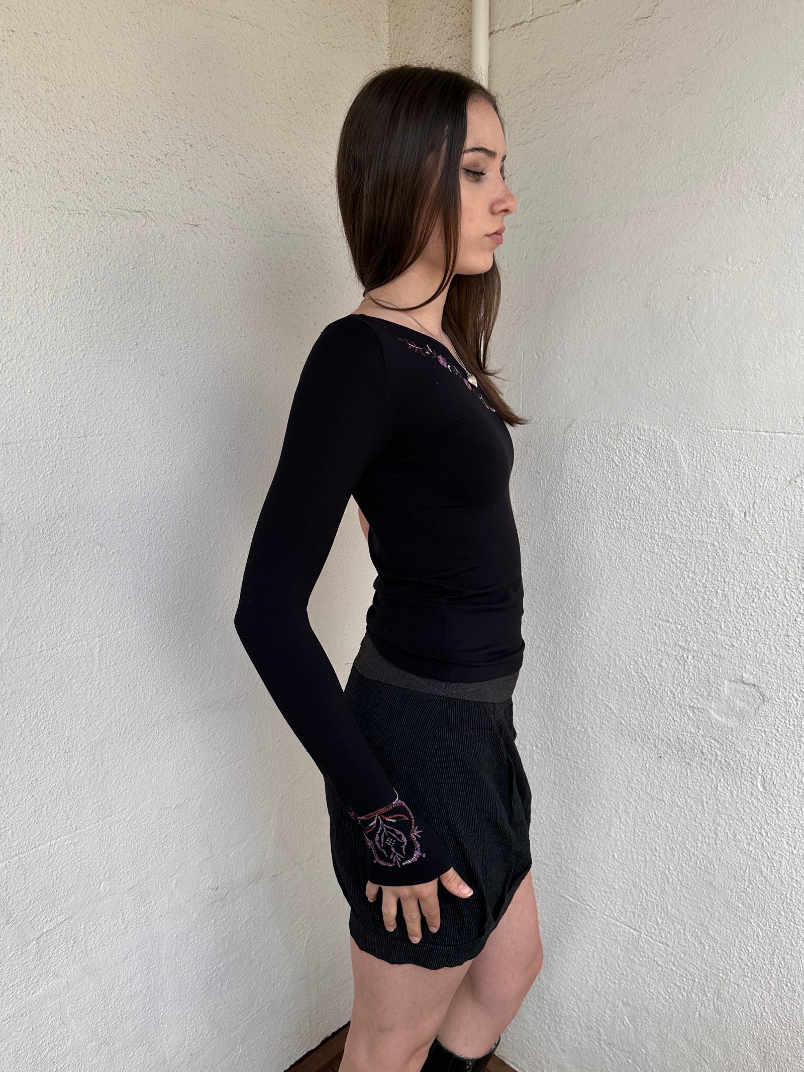 Woman wearing a Y2K 00s black one shoulder one sleeve with purple floral print 