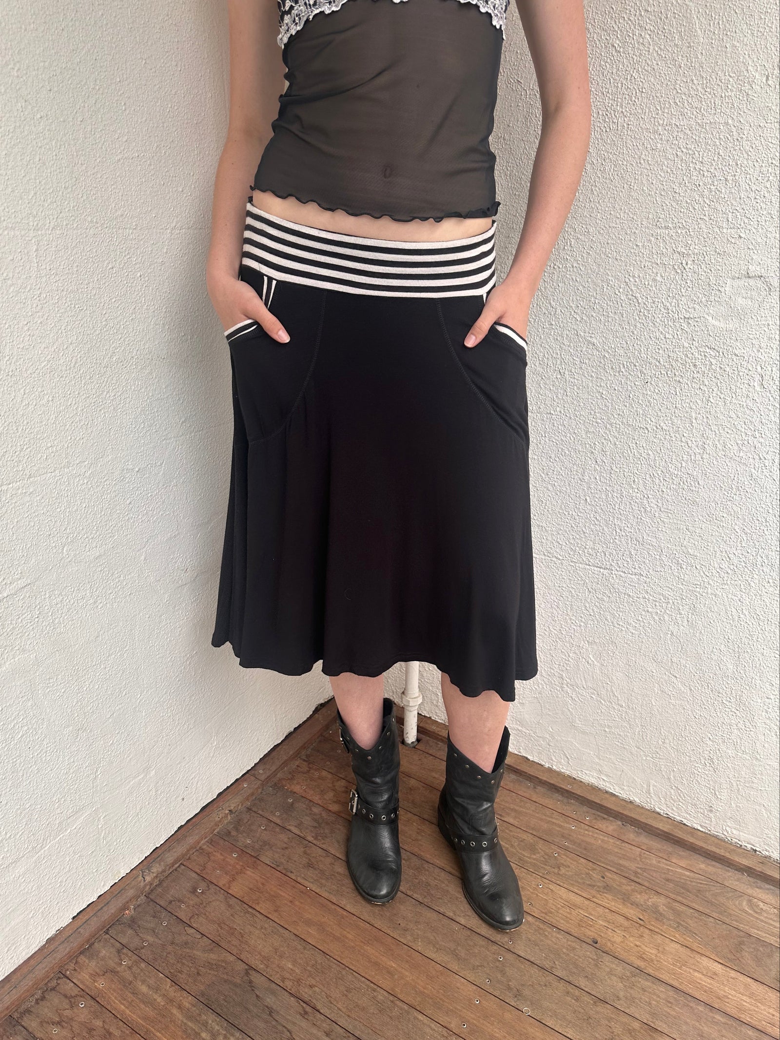 Woman wearing a Y2K 00s black & white stripe waistband midi skirt with stripe pockets