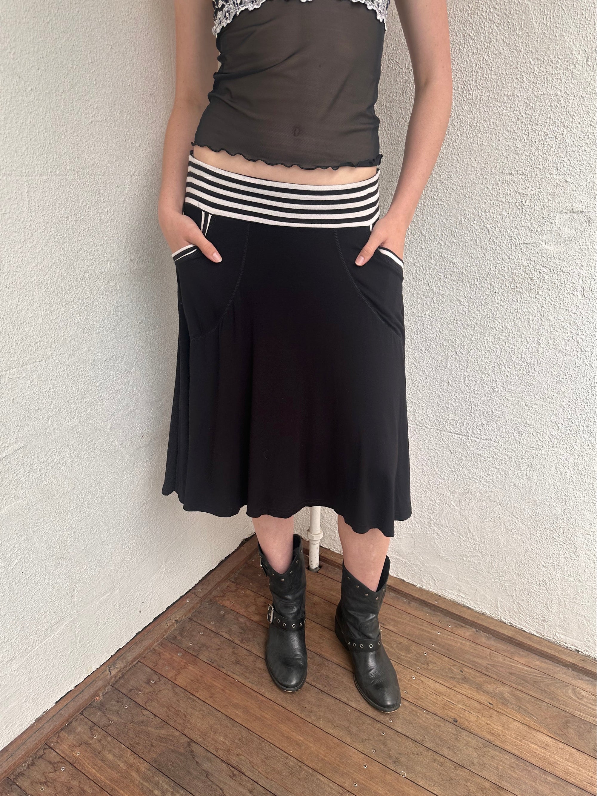 Woman wearing a Y2K 00s black & white stripe waistband midi skirt with stripe pockets