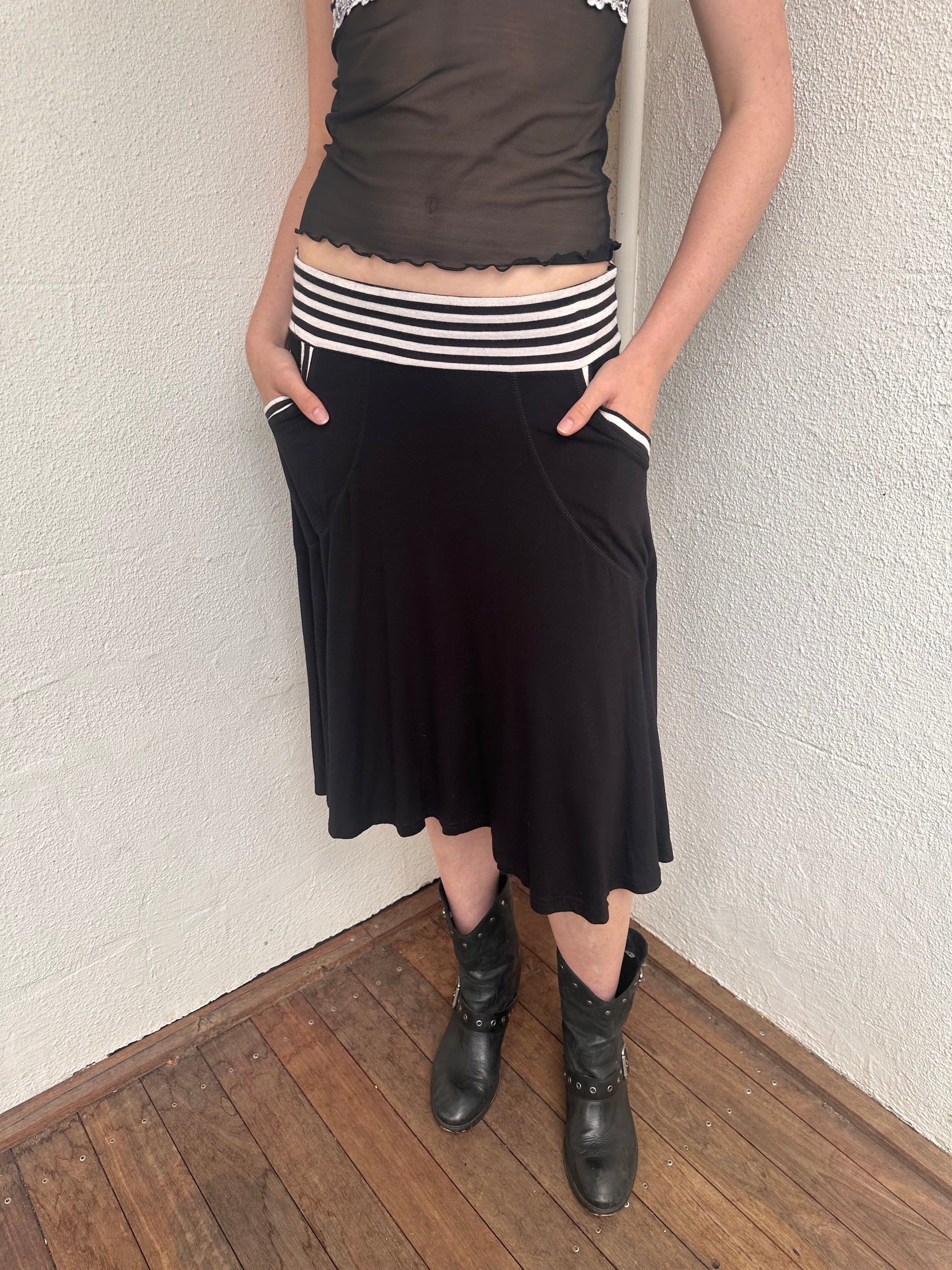 Woman wearing a Y2K 00s black & white stripe waistband midi skirt with stripe pockets