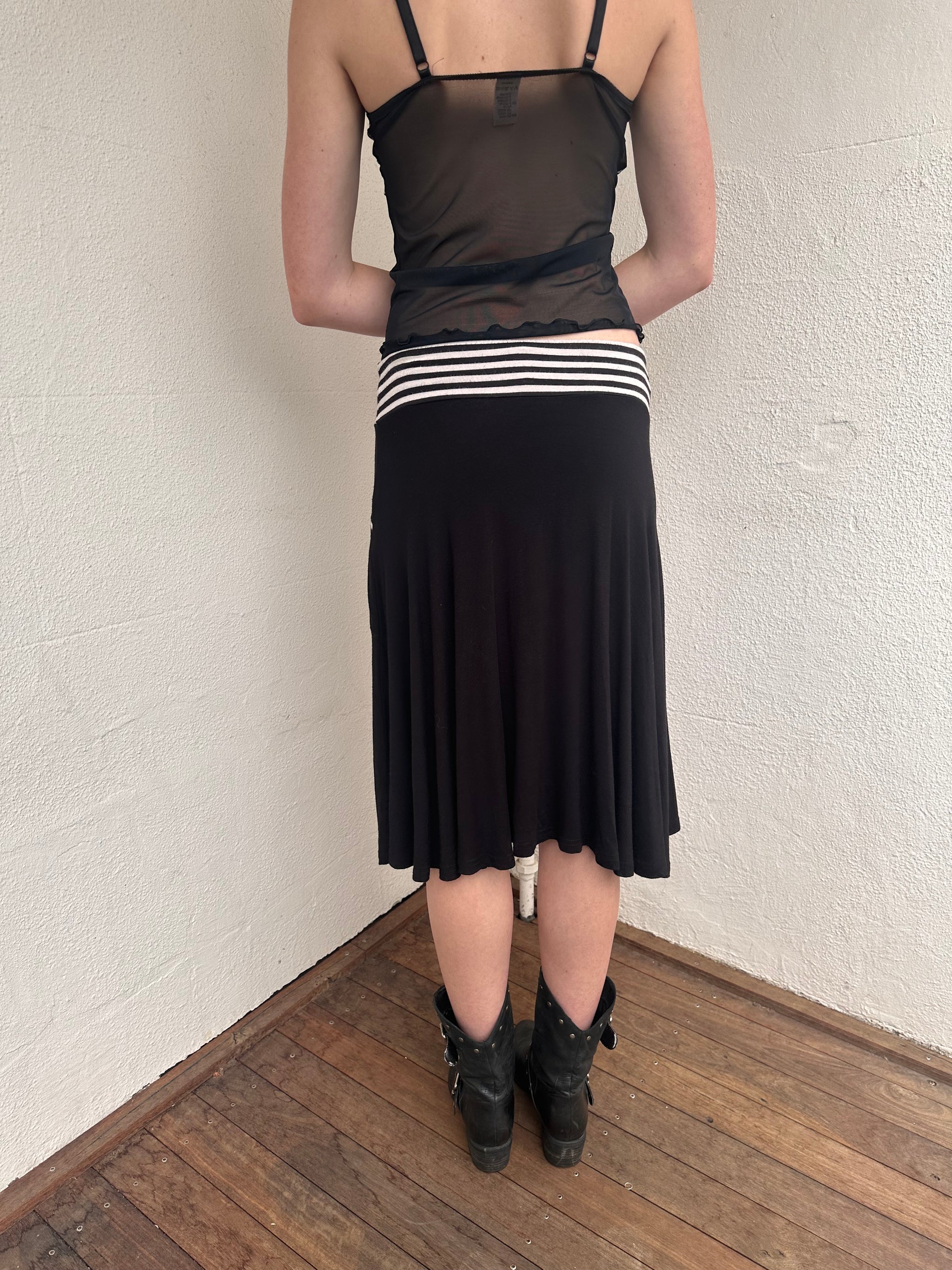 Woman wearing a Y2K 00s black & white stripe waistband midi skirt with stripe pockets from the back