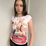 Woman wearing a Y2K 00s Coca Cola family print T-shirt