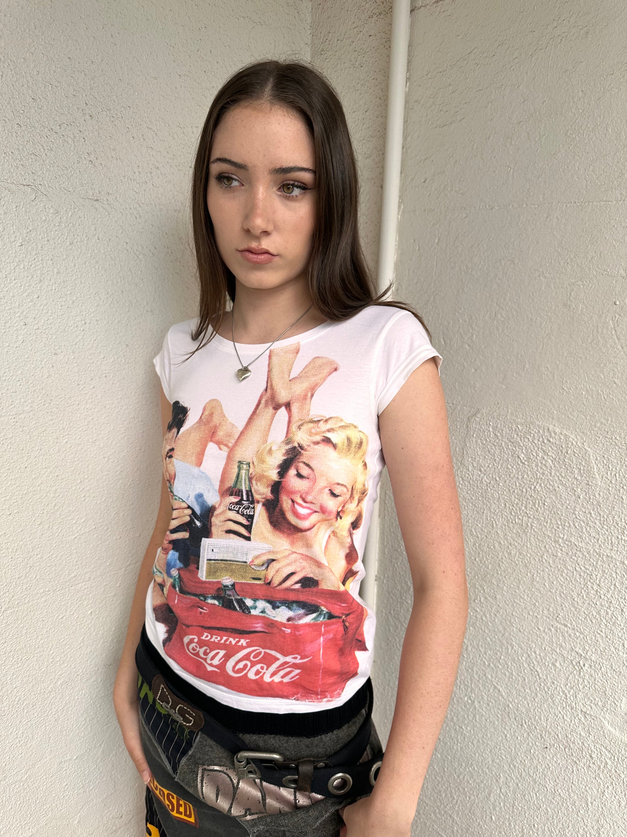 Woman wearing a Y2K 00s Coca Cola family print T-shirt