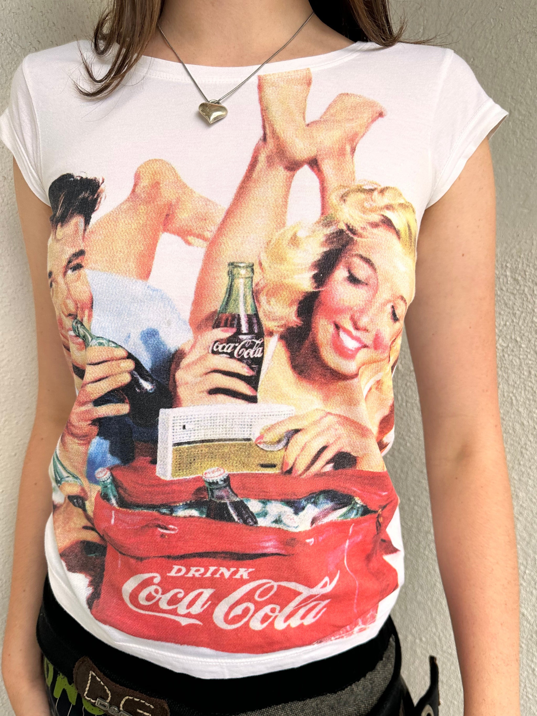 Woman wearing a Y2K 00s Coca Cola family print T-shirt