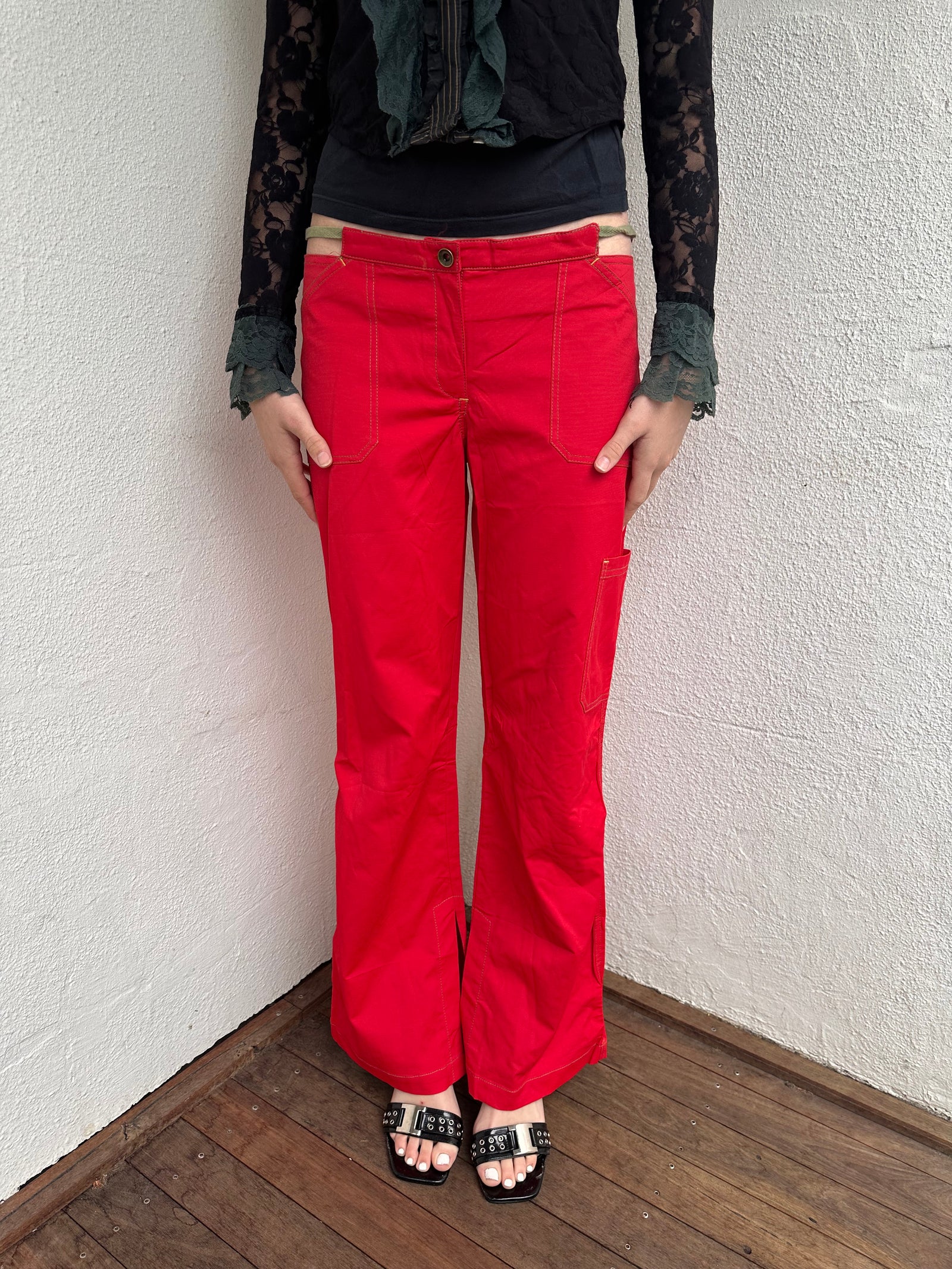 Woman wearing a Y2K 00s Cop copine red straight leg and low waited pants with cut out waistband and yellow embroidery 