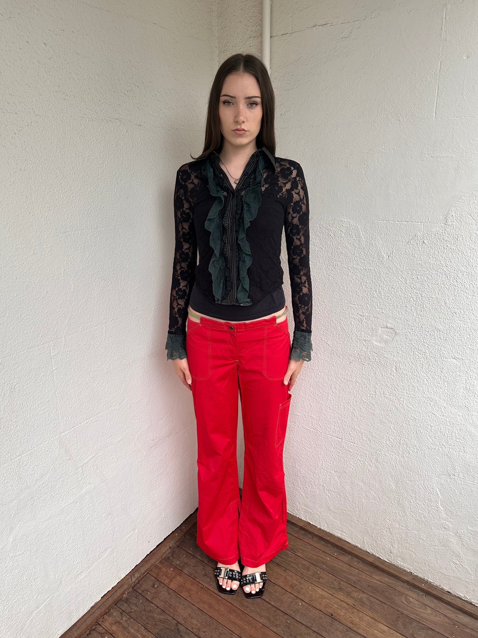 Woman wearing a Y2K 00s Cop copine red straight leg and low waited pants with cut out waistband and yellow embroidery 