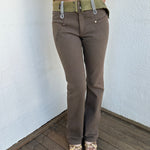 Woman wearing a Y2K 00s  Khaki flare  Jeans with attached utility belt 
