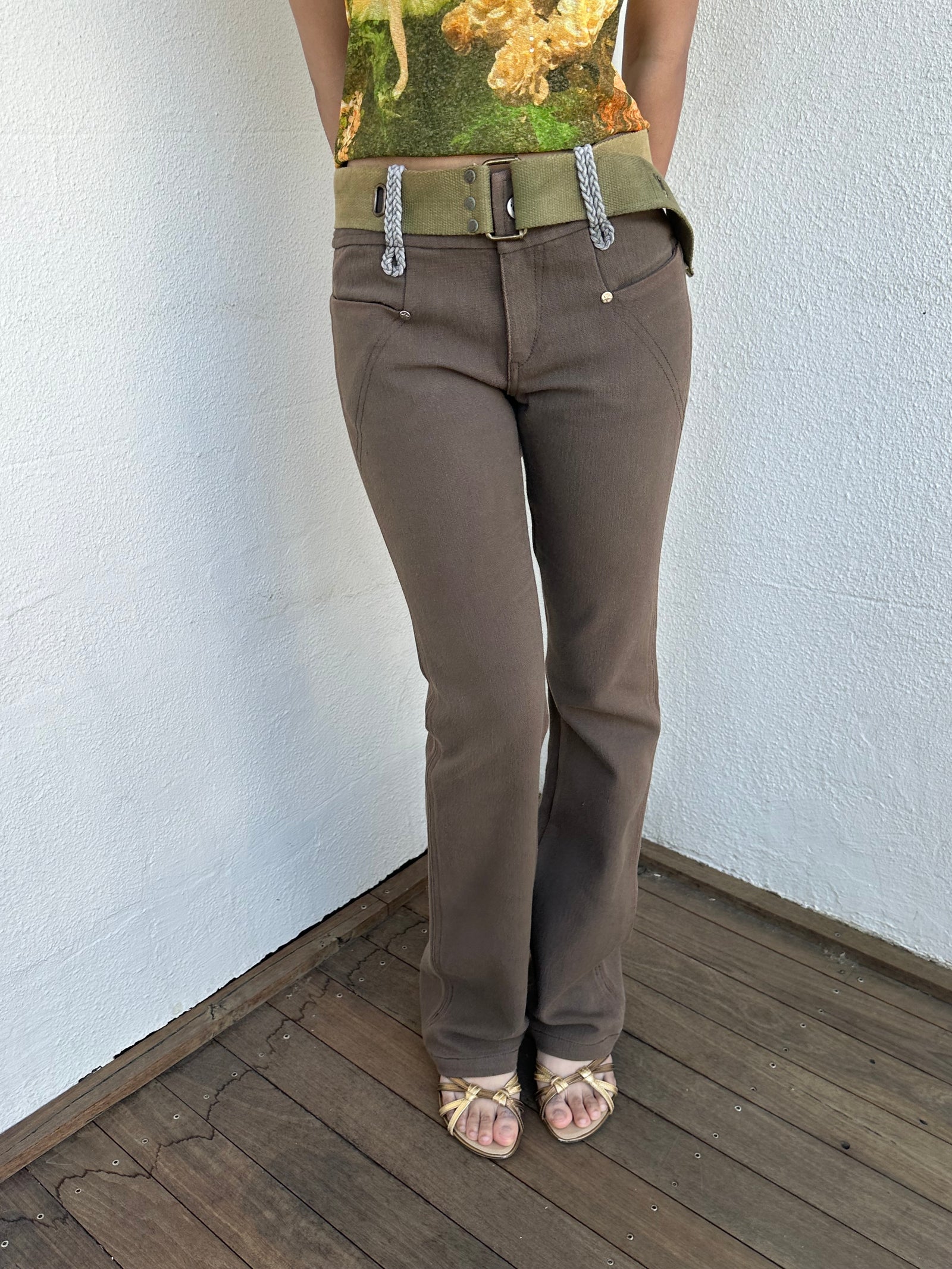 Woman wearing a Y2K 00s  Khaki flare  Jeans with attached utility belt 
