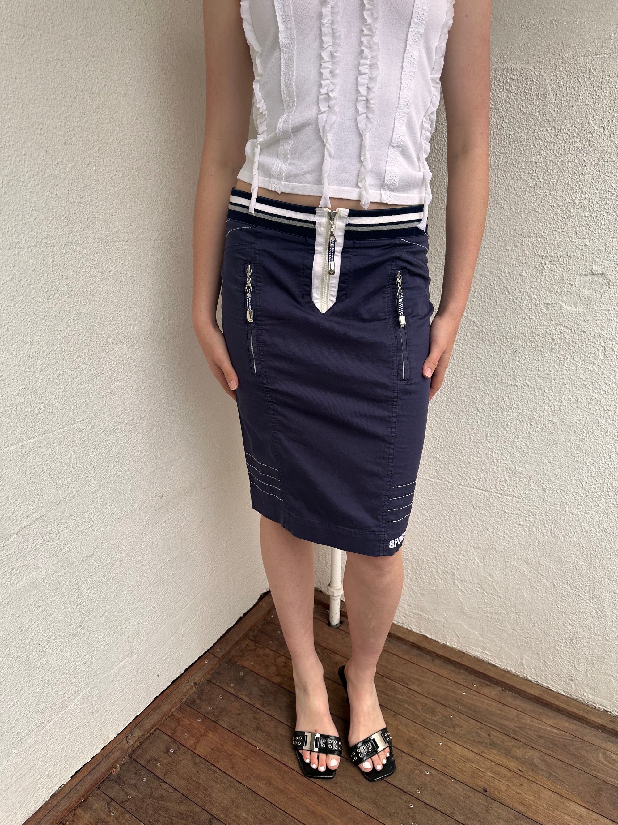 Woman wearing a Y2K 00s sportalm navy and white sporty midi skirt 