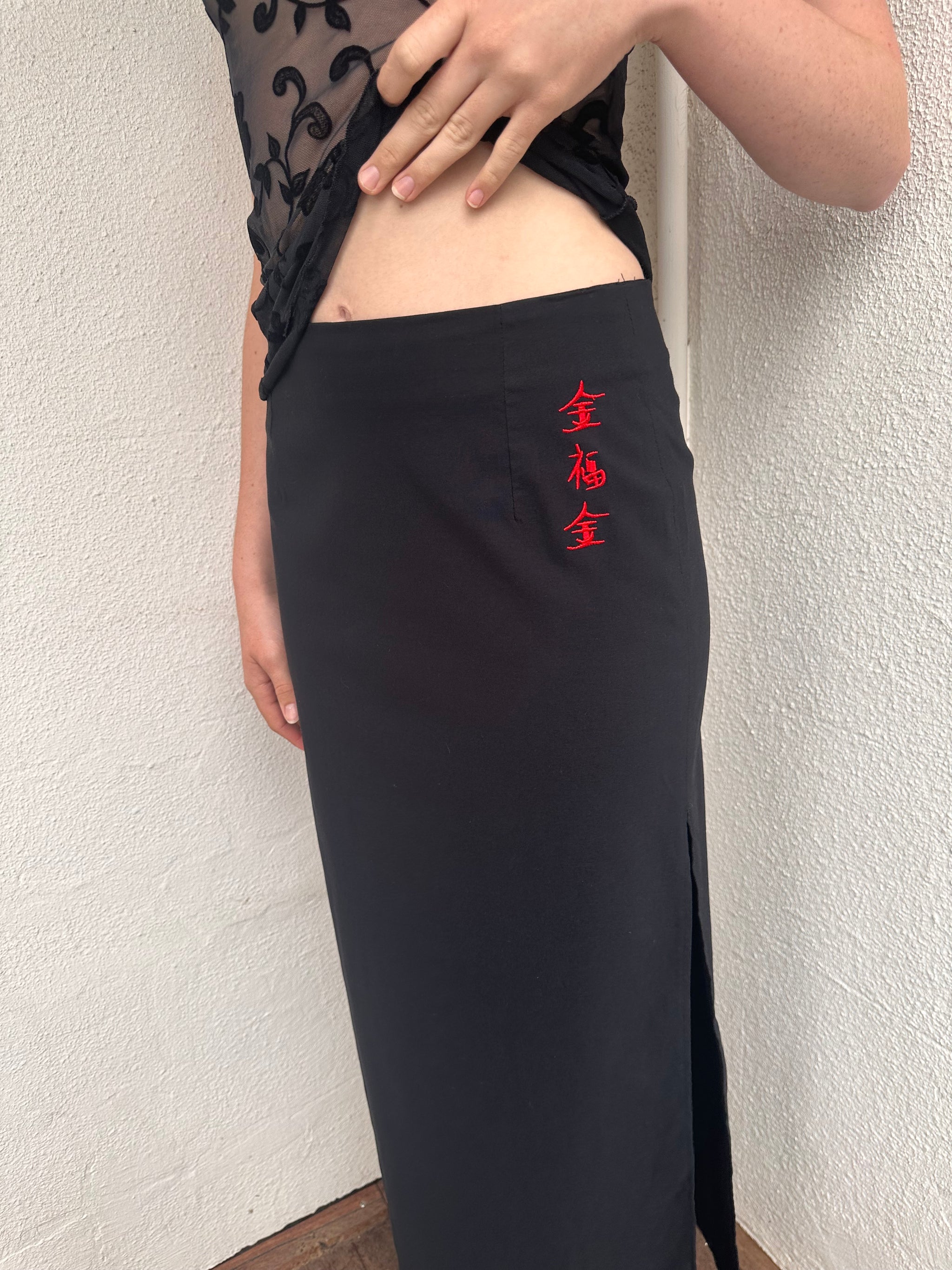 Woman wearing a Y2K 00s pimkie Y2K black with Chinese red embroidered details maxi skirt 