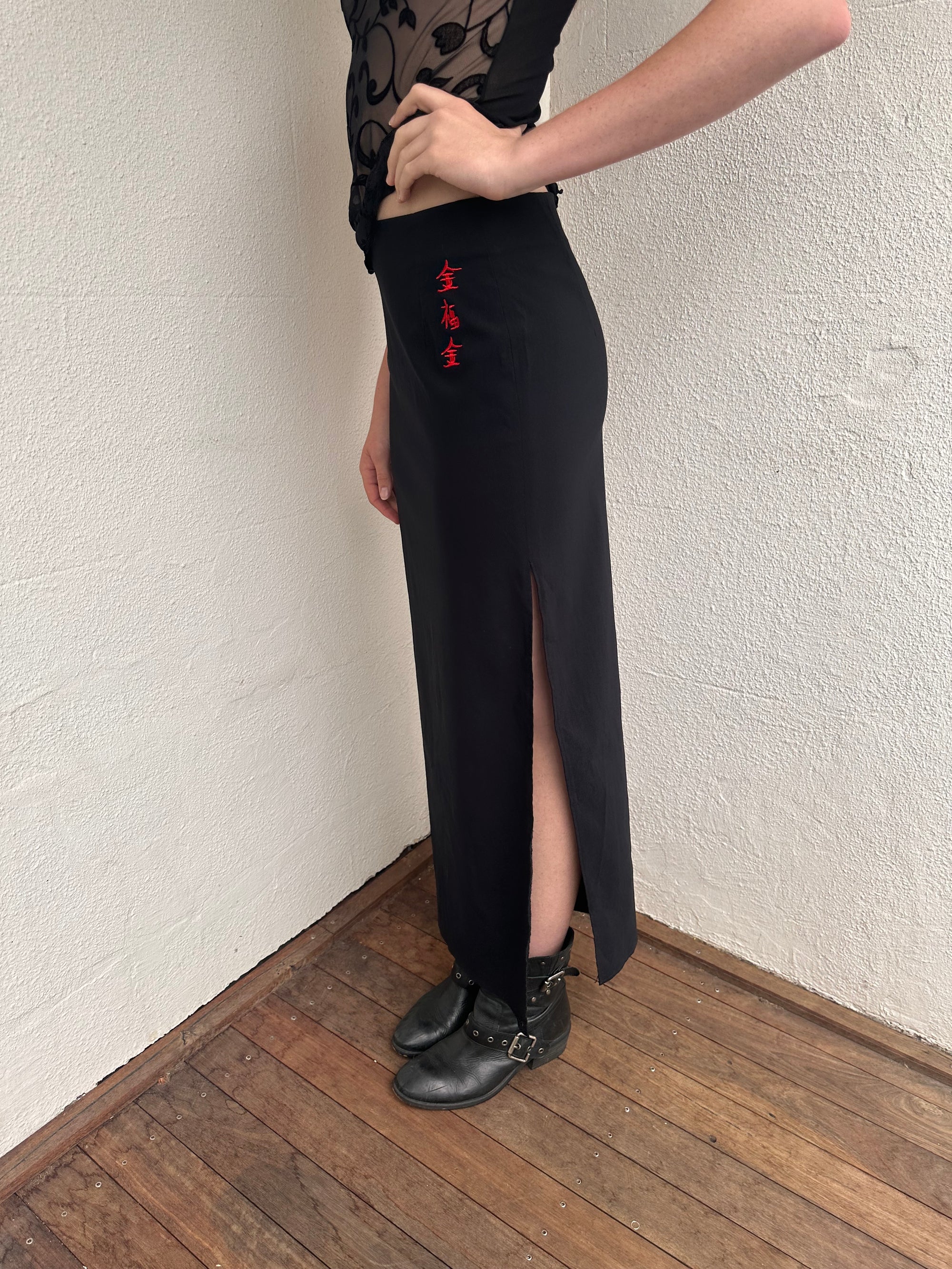 Woman wearing a Y2K 00s pimkie Y2K black with Chinese red embroidered details maxi skirt 
