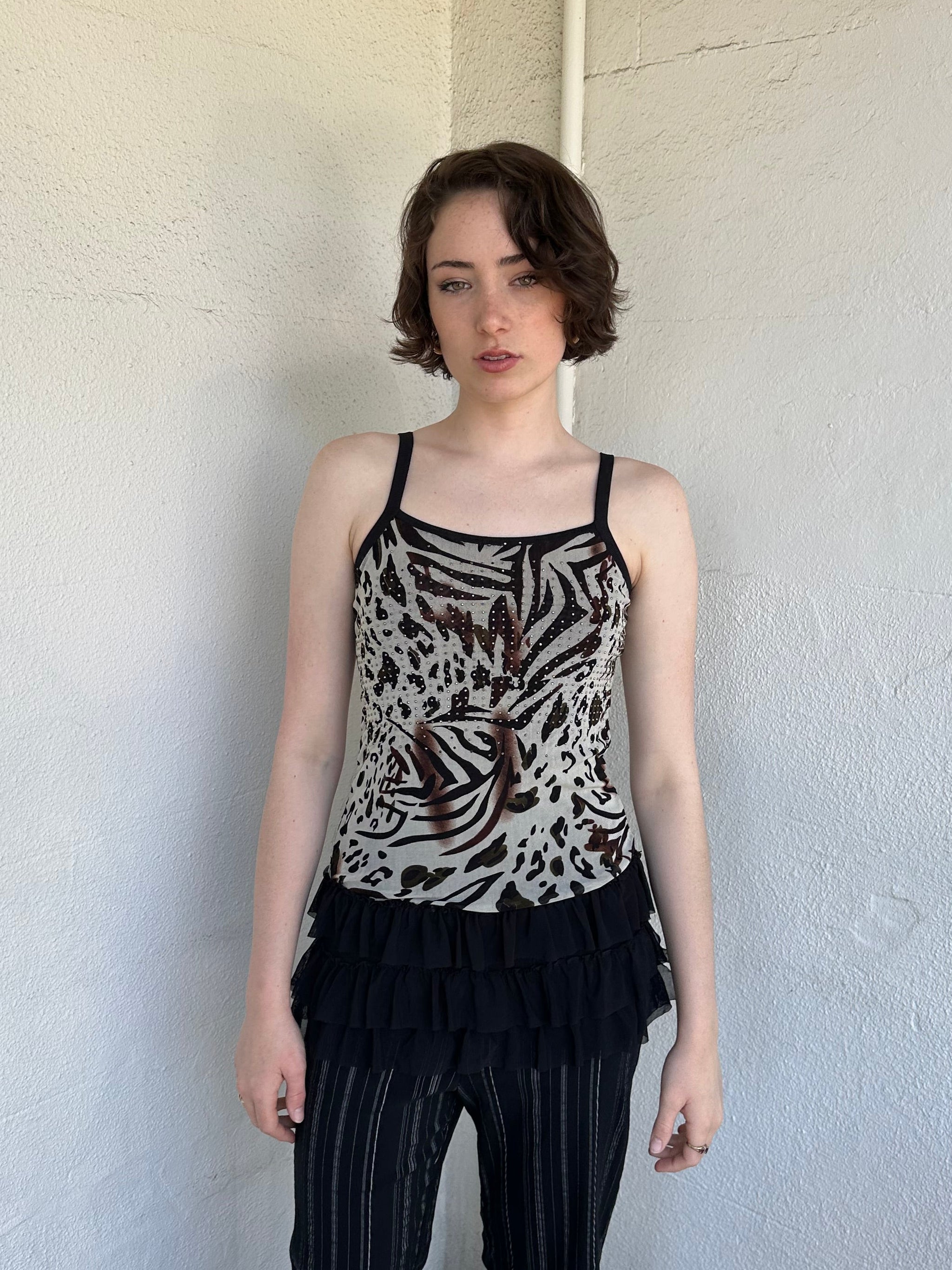 Woman Dressed in Y2K Animal print rhinestone top featuring a cream and brown zebra-style patterned body with rhinestone embellishment throughout.