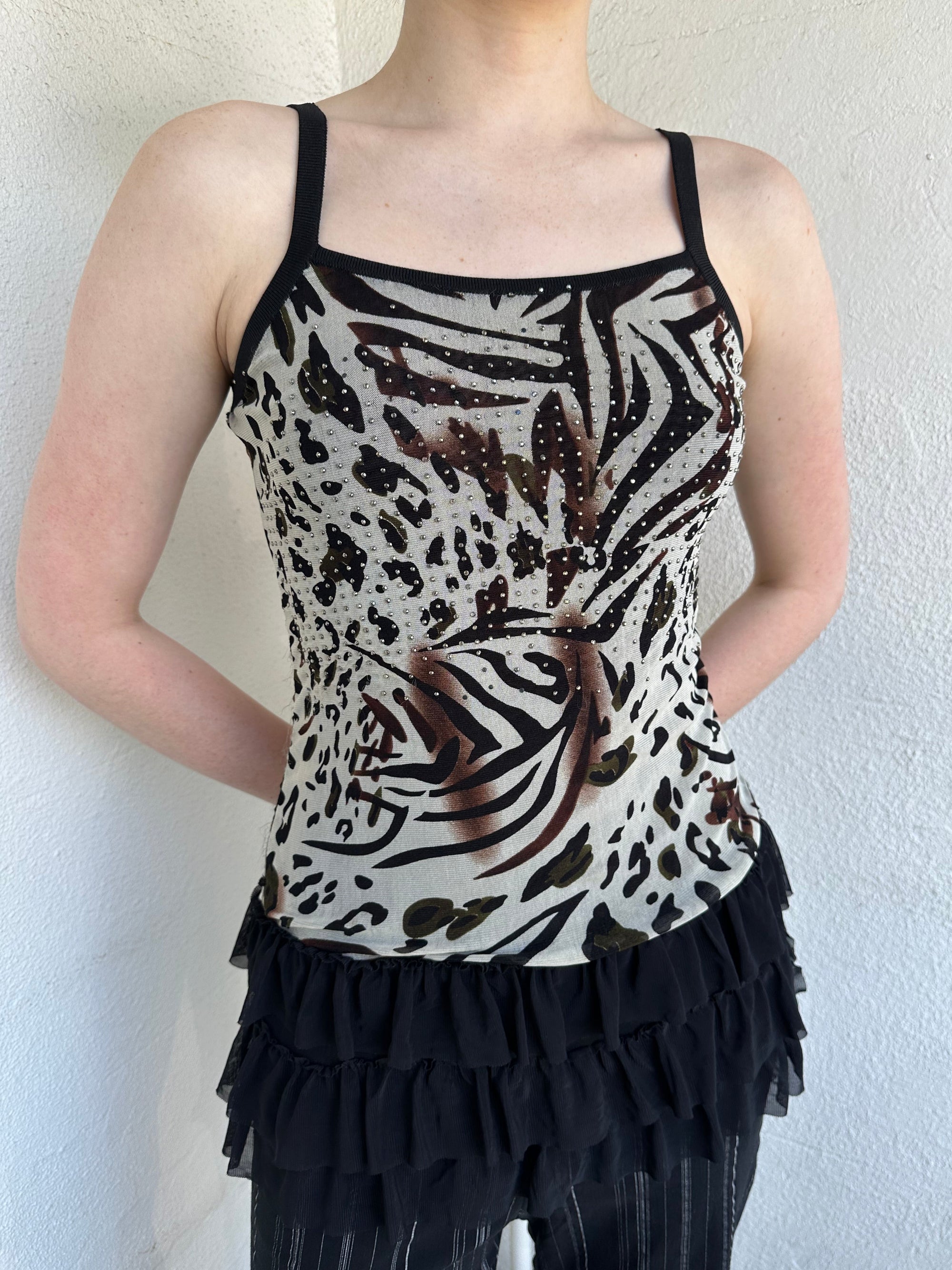 Woman Dressed in Y2K Animal print rhinestone top featuring a cream and brown zebra-style patterned body with rhinestone embellishment throughout.