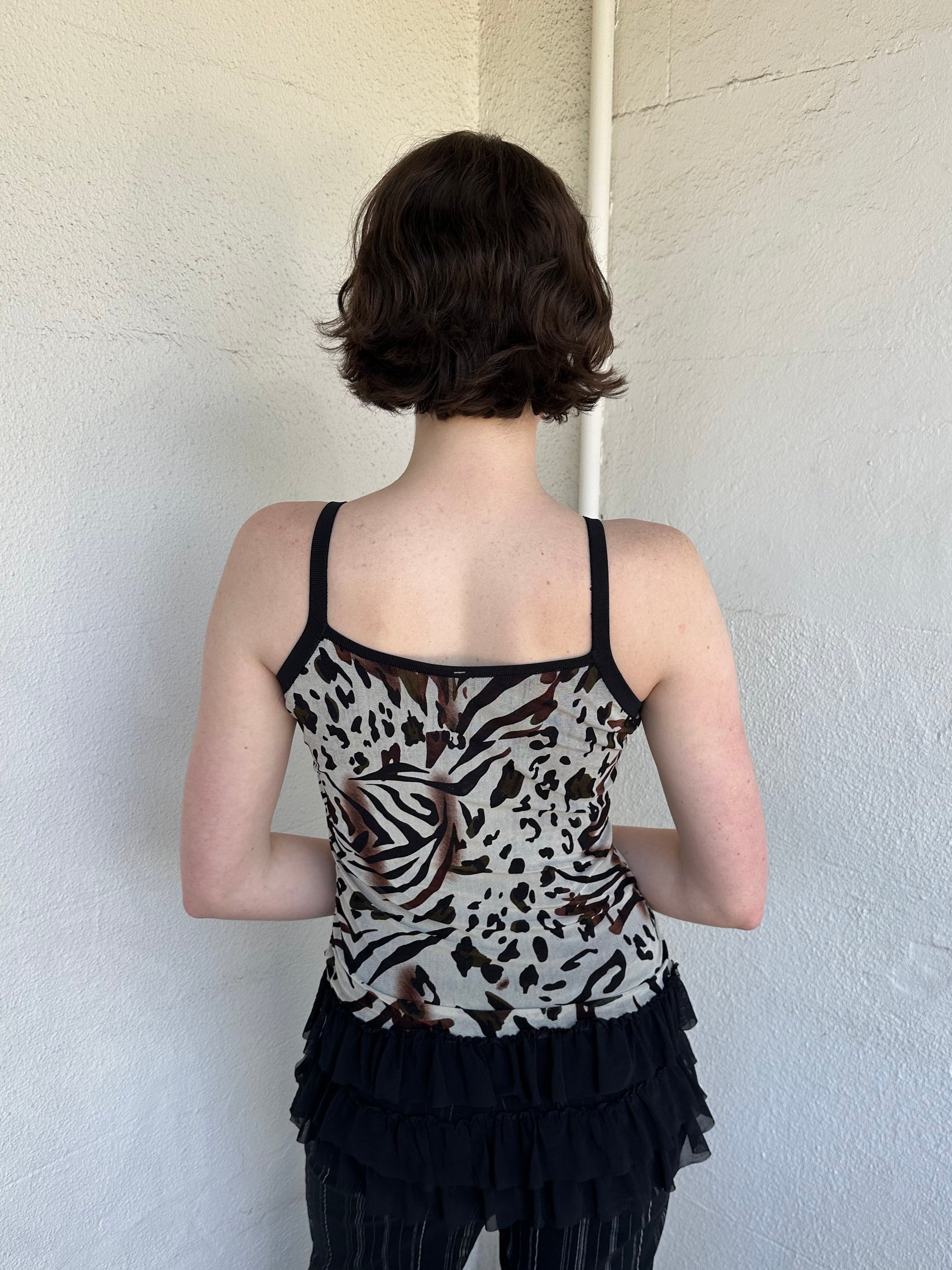 Woman Dressed in Y2K Animal print rhinestone top featuring a cream and brown zebra-style patterned body with rhinestone embellishment throughout.