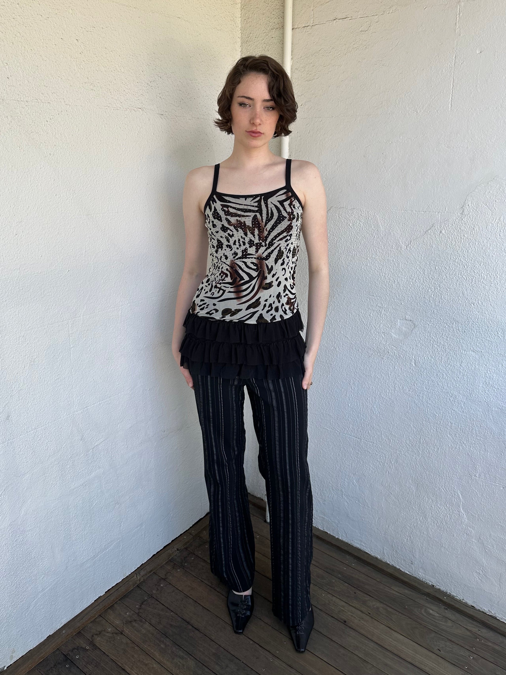 Woman Dressed in Y2K Animal print rhinestone top featuring a cream and brown zebra-style patterned body with rhinestone embellishment throughout.