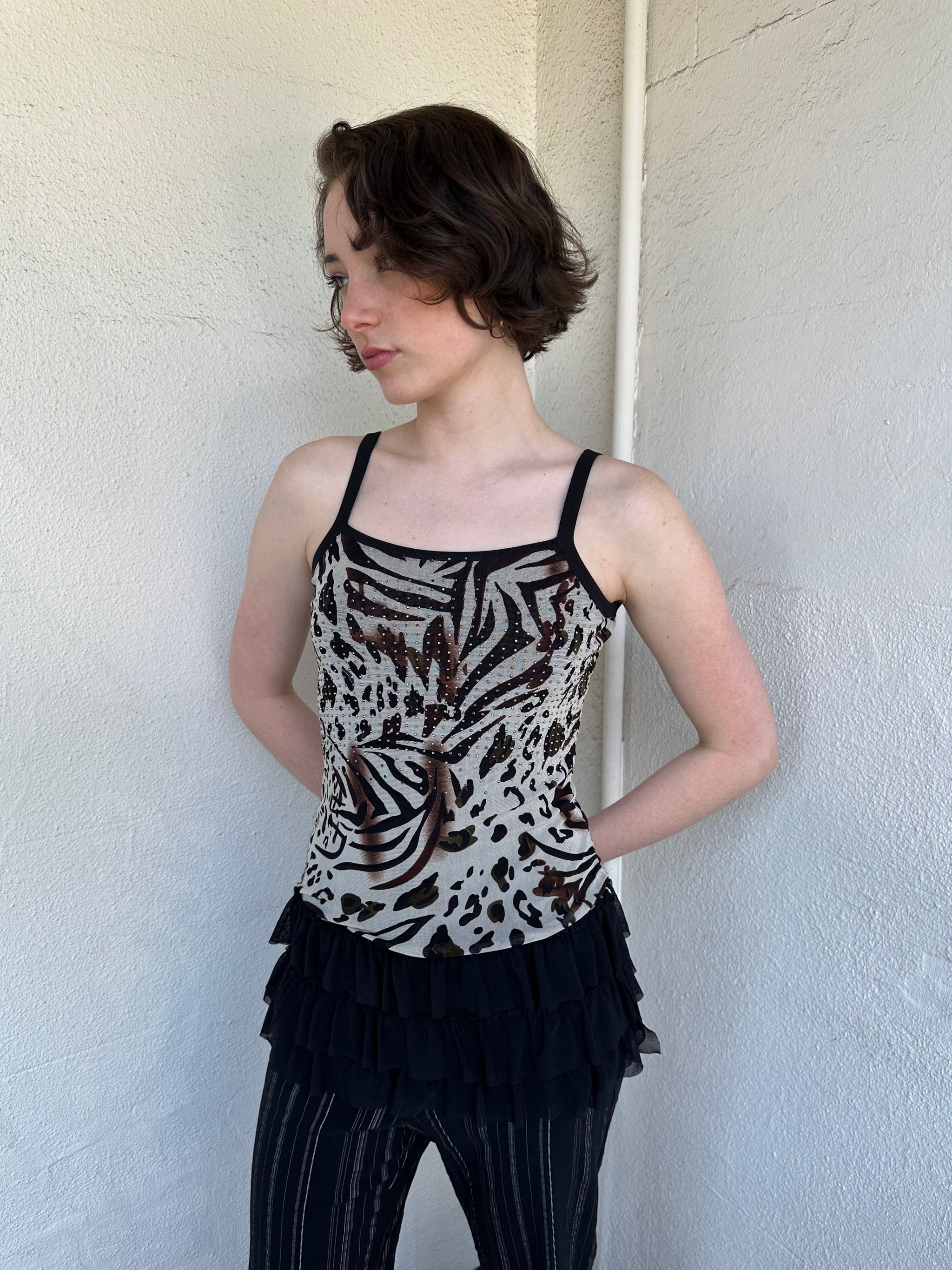 Woman Dressed in Y2K Animal print rhinestone top featuring a cream and brown zebra-style patterned body with rhinestone embellishment throughout.