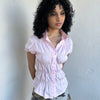 Women wearing a 00s Y2K Baby pink reworked cinched shirt featuring gathered detailing at the waist for a fitted silhouette.