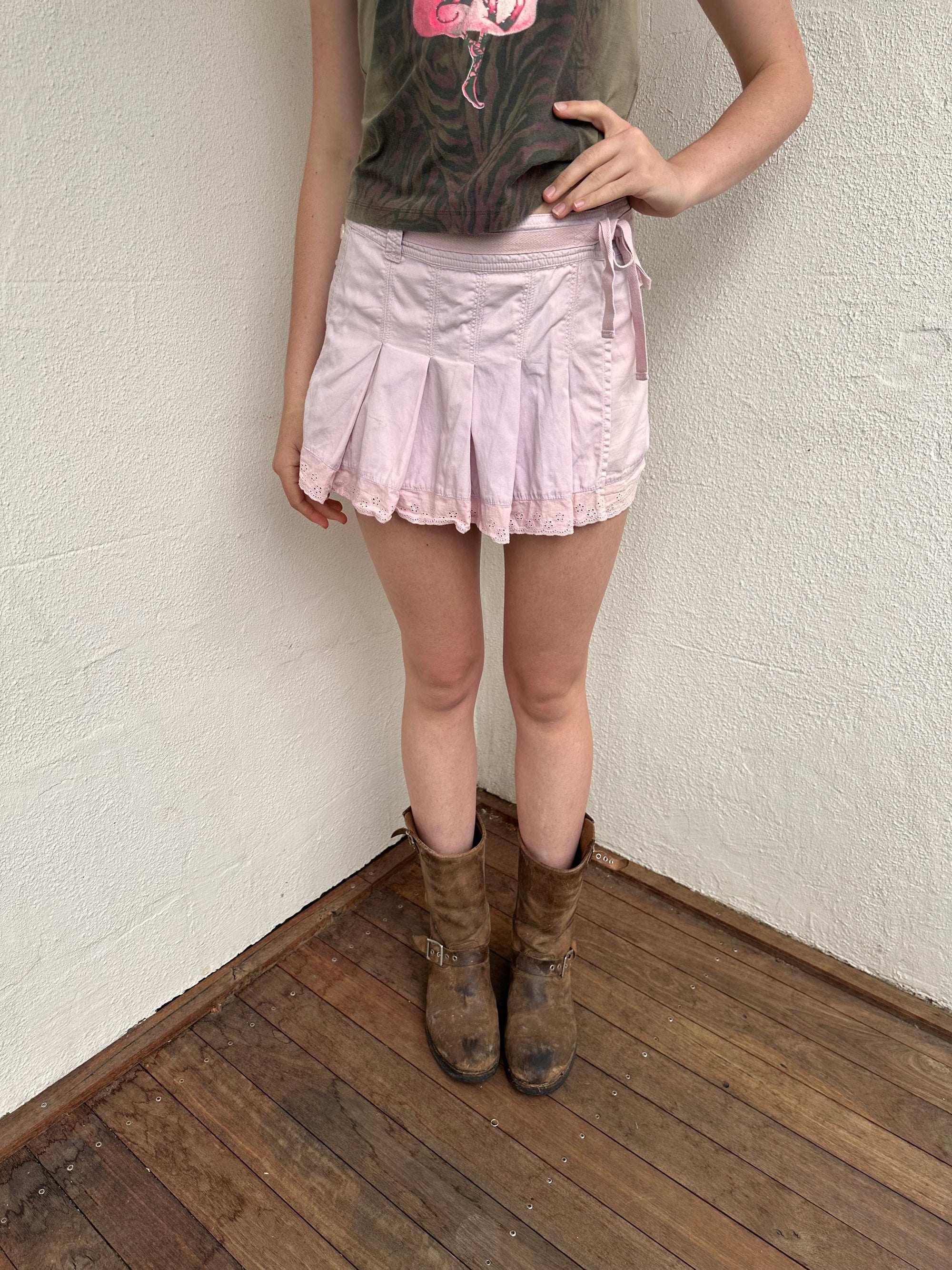 Woman wearing a Y2K 00s Baby Pink Pleated Wrap Mini Skirt