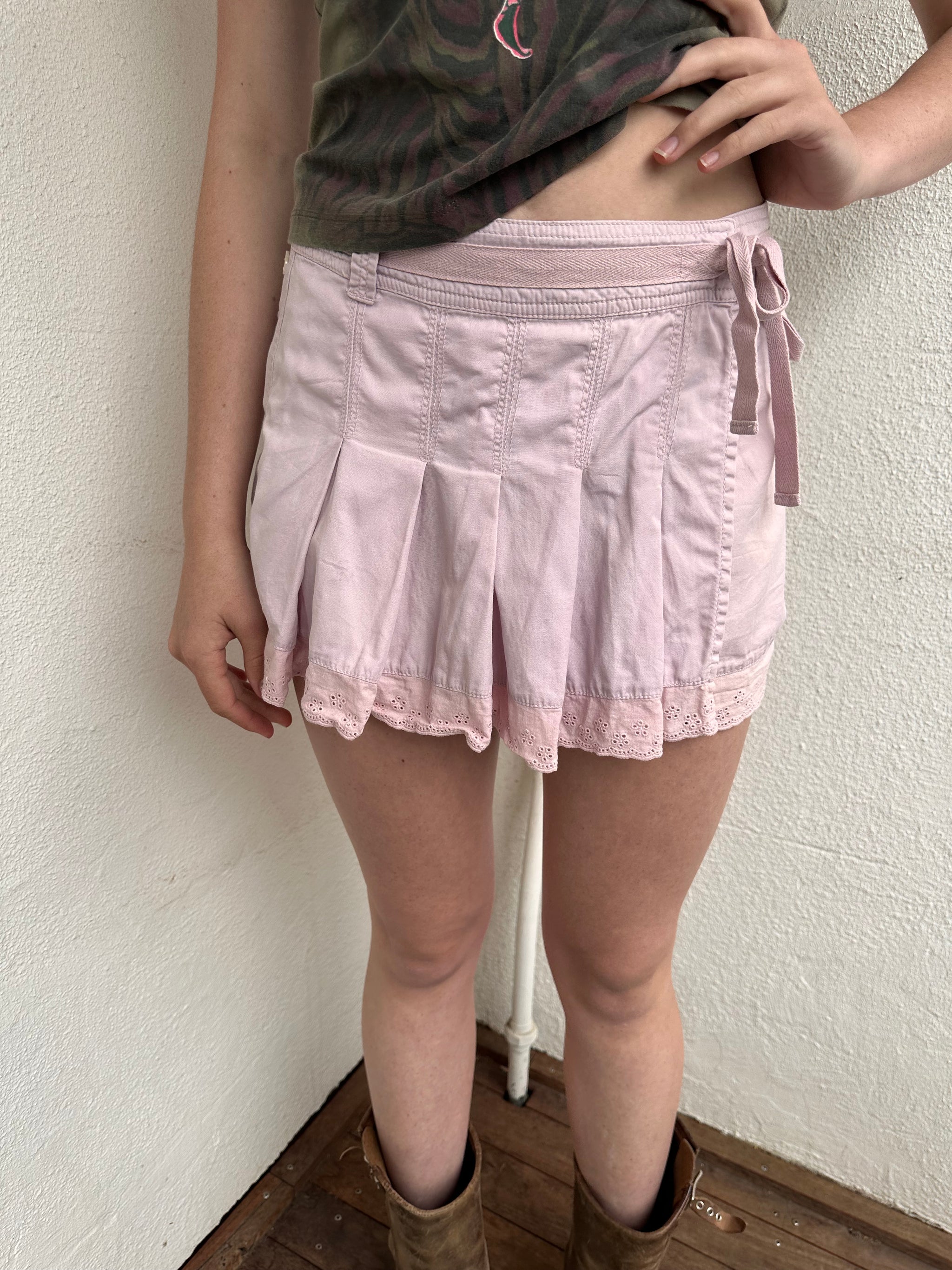 Woman wearing a Y2K 00s Baby Pink Pleated Wrap Mini Skirt