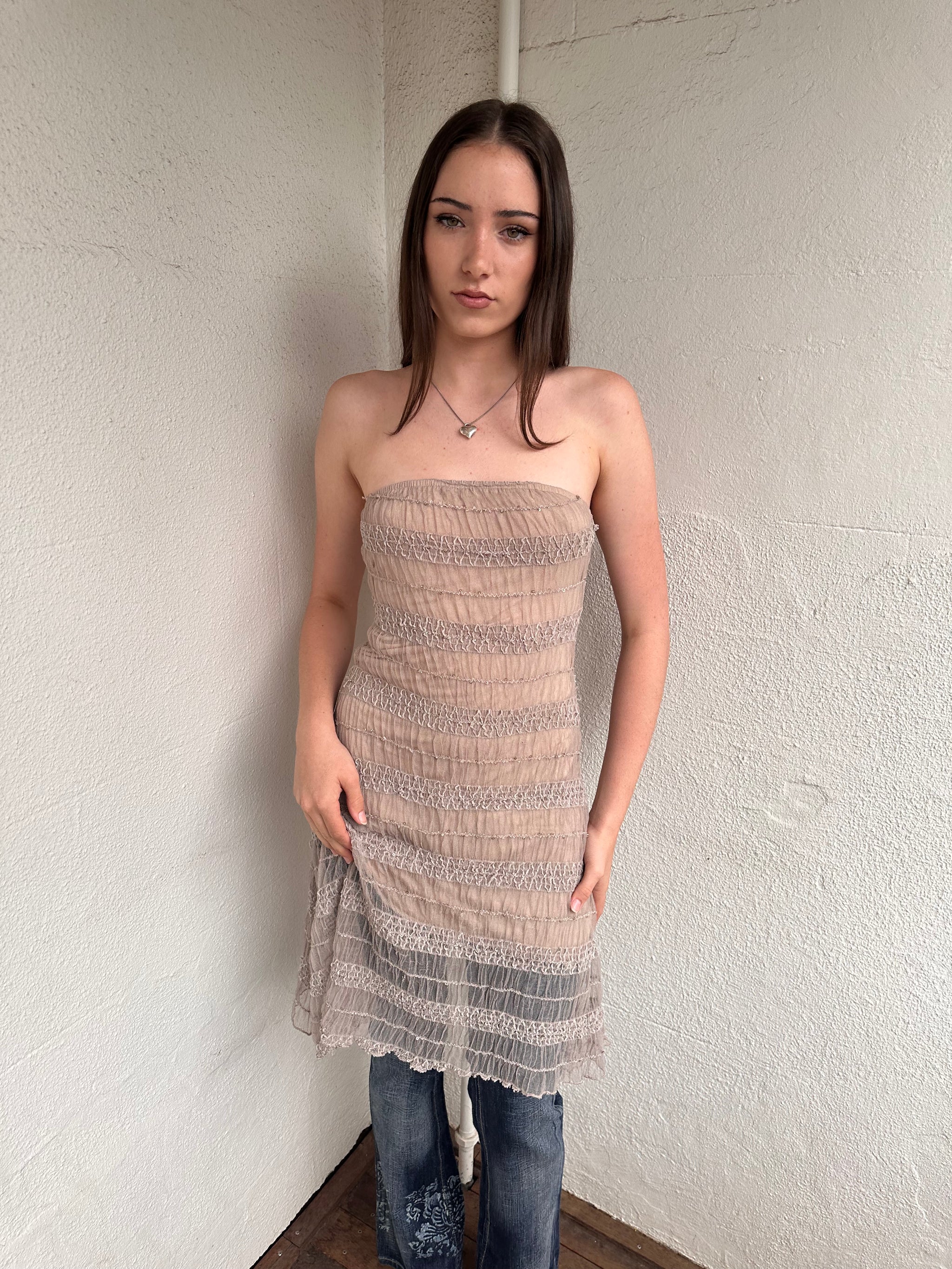 Woman wearing a Y2K 00s Beige mesh strapless dress features a textured, semi-sheer design that channels effortless festival vibes. 
