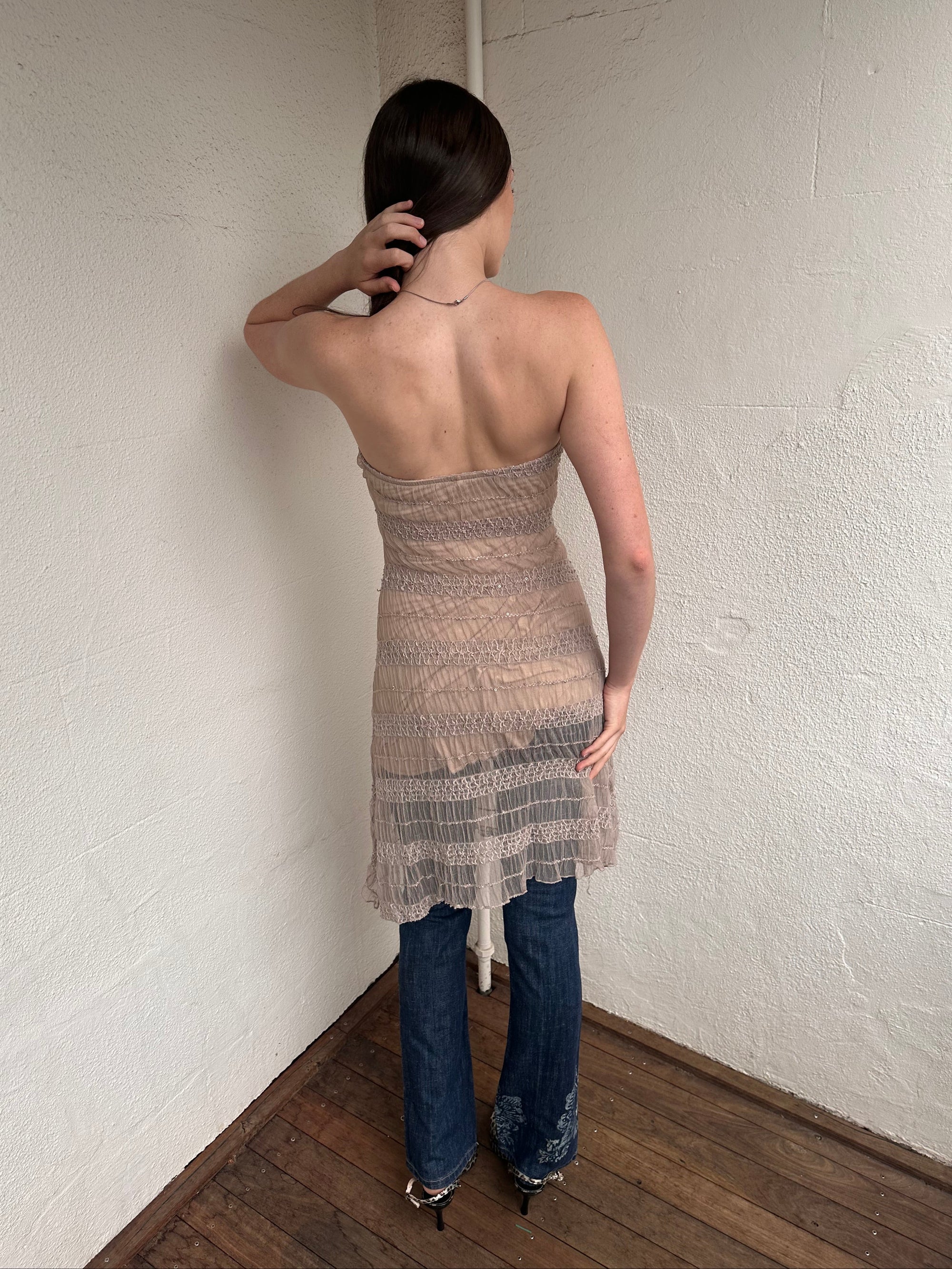 Woman wearing a Y2K 00s Beige mesh strapless dress features a textured, semi-sheer design that channels effortless festival vibes. 