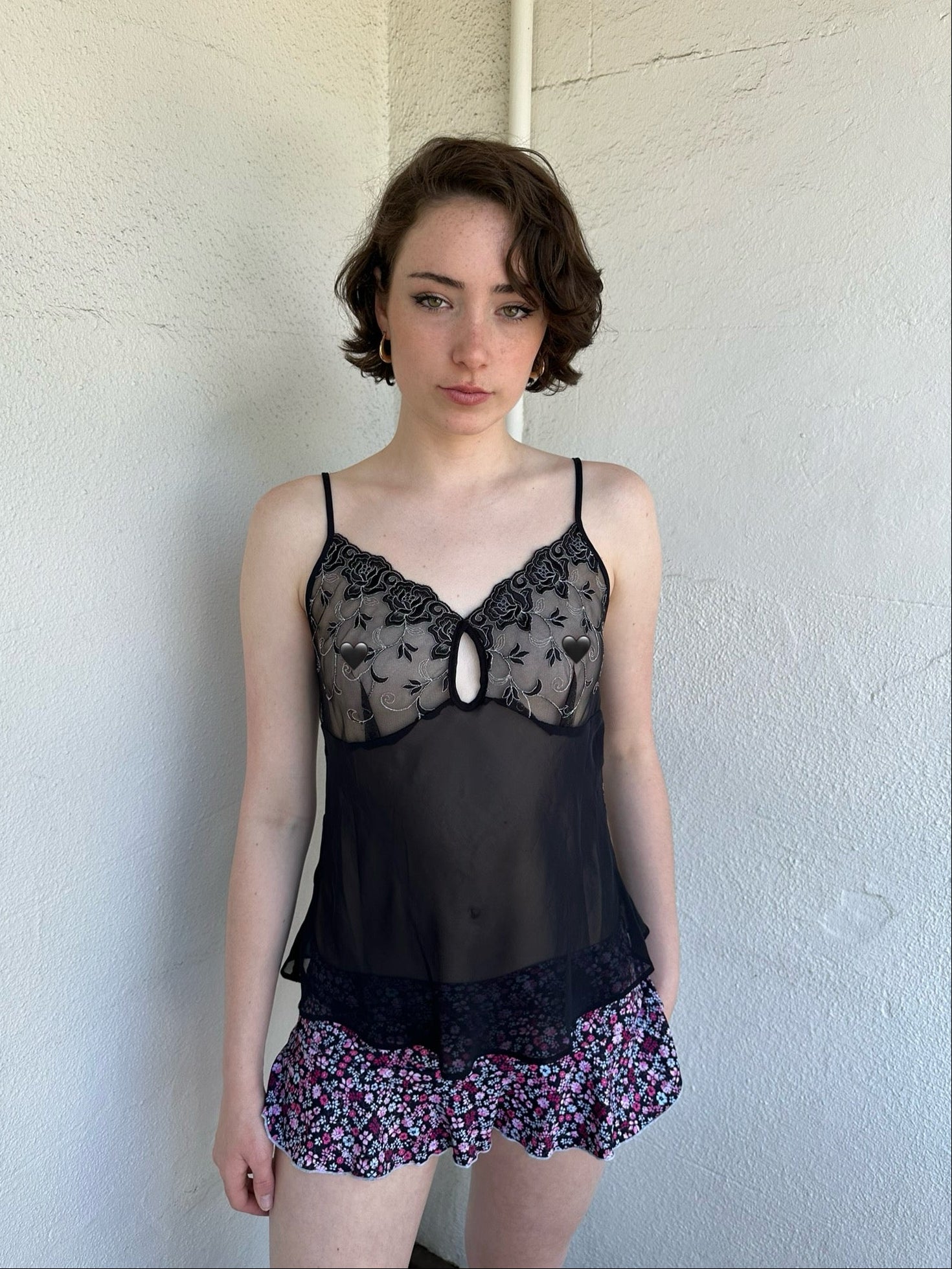 Woman Dressed in Y2K Black embroidered mesh cami top featuring a sheer bust with black and silver floral embroidery. 