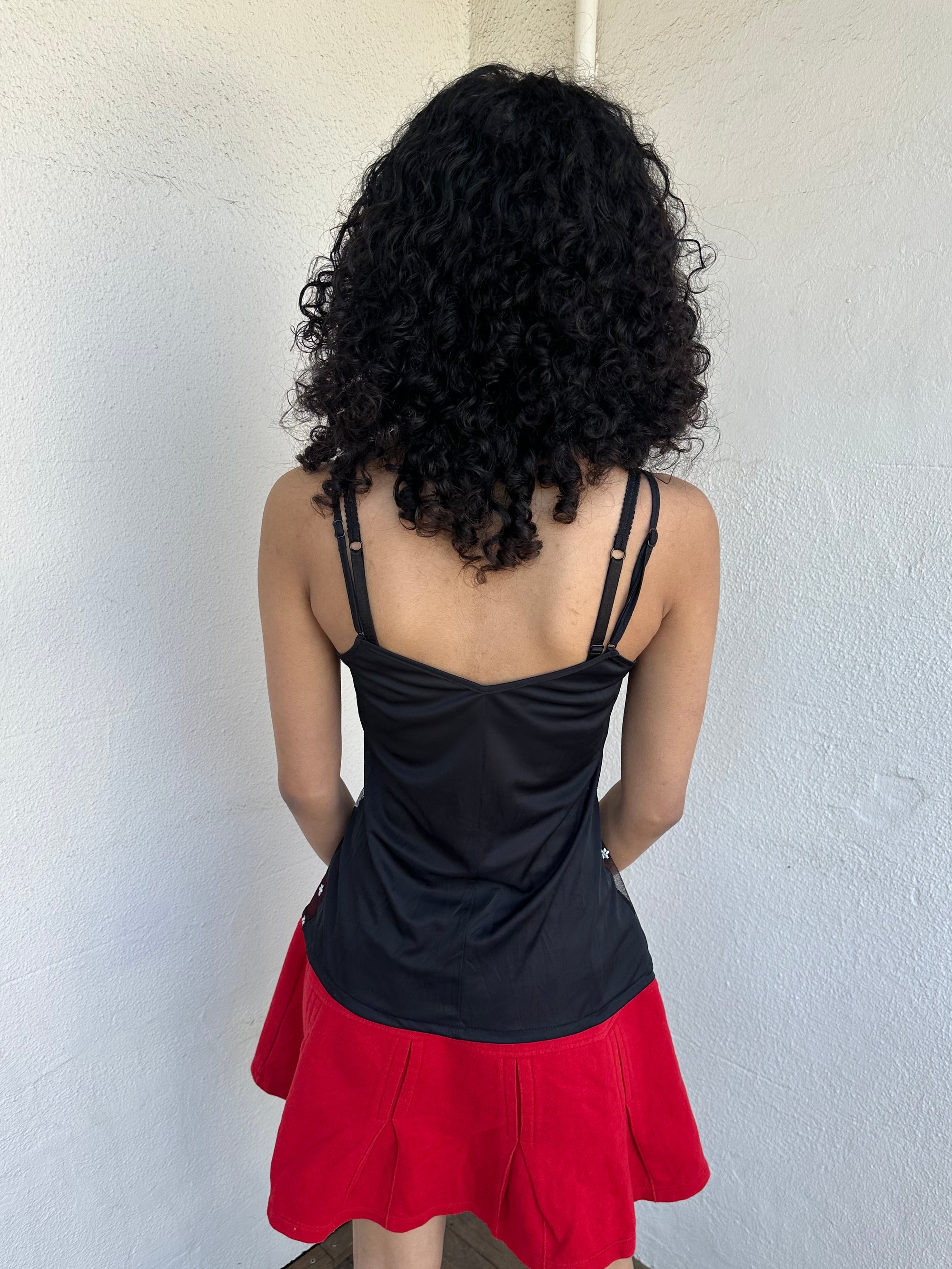 Woman wearing a Y2K 00s Black with white floral embroidery mesh cami top. Light blue floral embroidery featured 