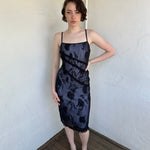Woman Dressed in Y2K Black floral lace midi dress featuring black lace layered over a white base.