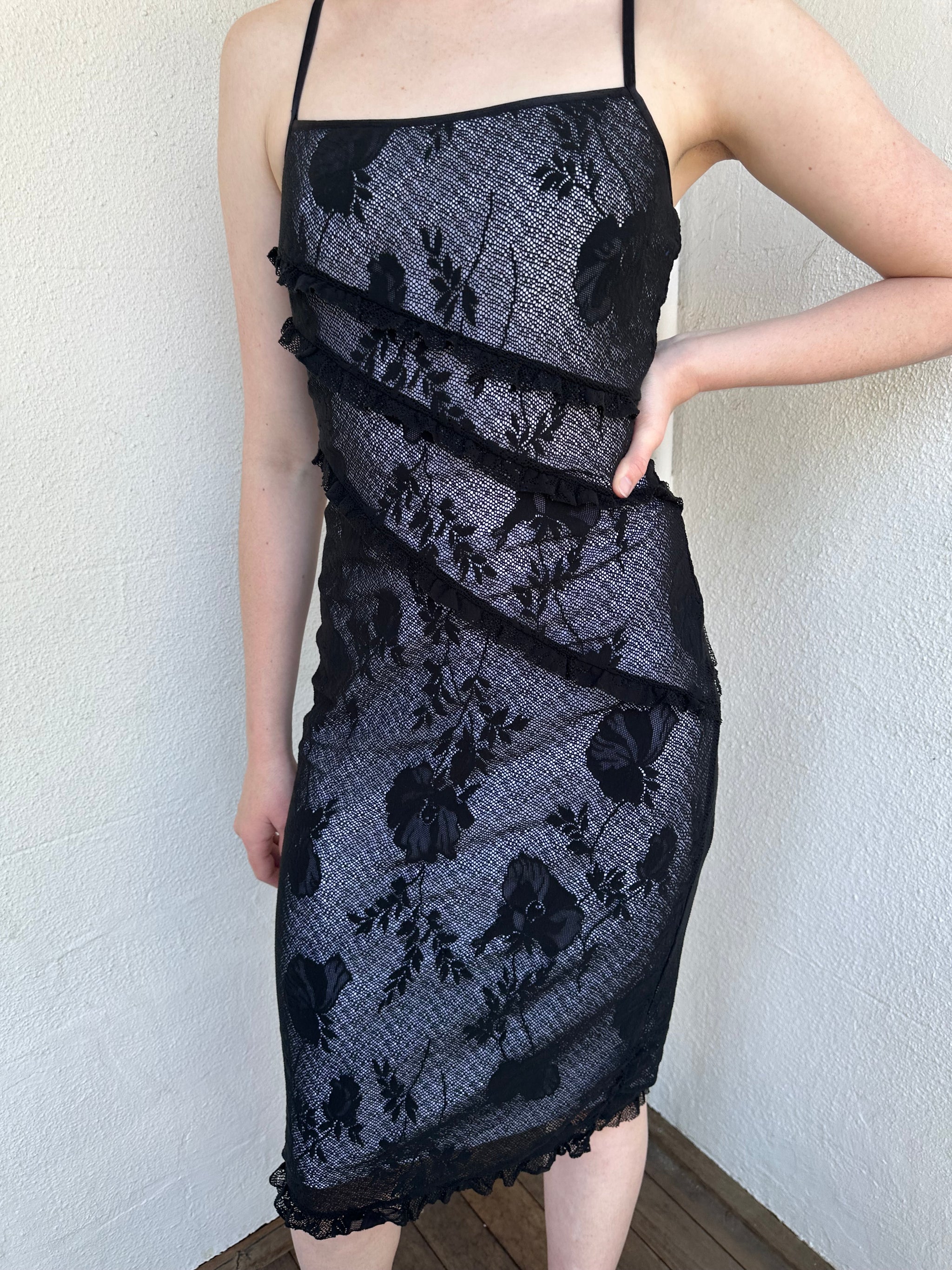Woman Dressed in Y2K Black floral lace midi dress featuring black lace layered over a white base.