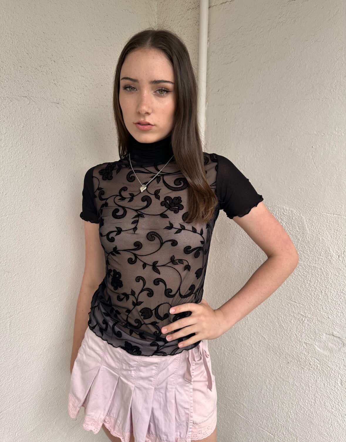 Women wearing a 00s Y2K Black floral sheer mesh turtleneck t-shirt featuring an all-over delicate floral pattern. 