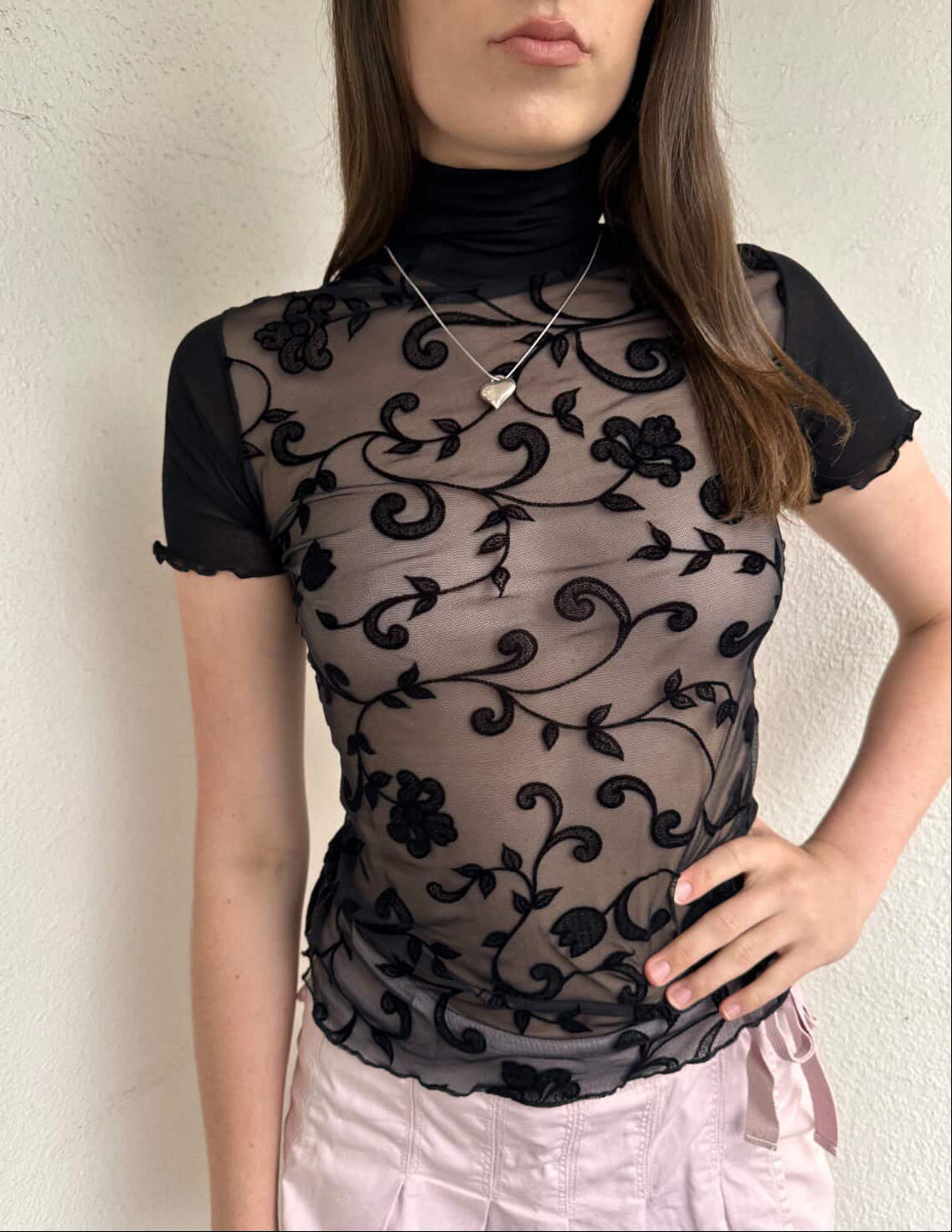 Women wearing a 00s Y2K Black floral sheer mesh turtleneck t-shirt featuring an all-over delicate floral pattern. 
