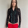 Women wearing a 00s Y2K Black and khaki lace long sleeve shirt with ruffled khaki lace along the front opening and cuffs. 