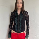 Women wearing a 00s Y2K Black and khaki lace long sleeve shirt with ruffled khaki lace along the front opening and cuffs. 