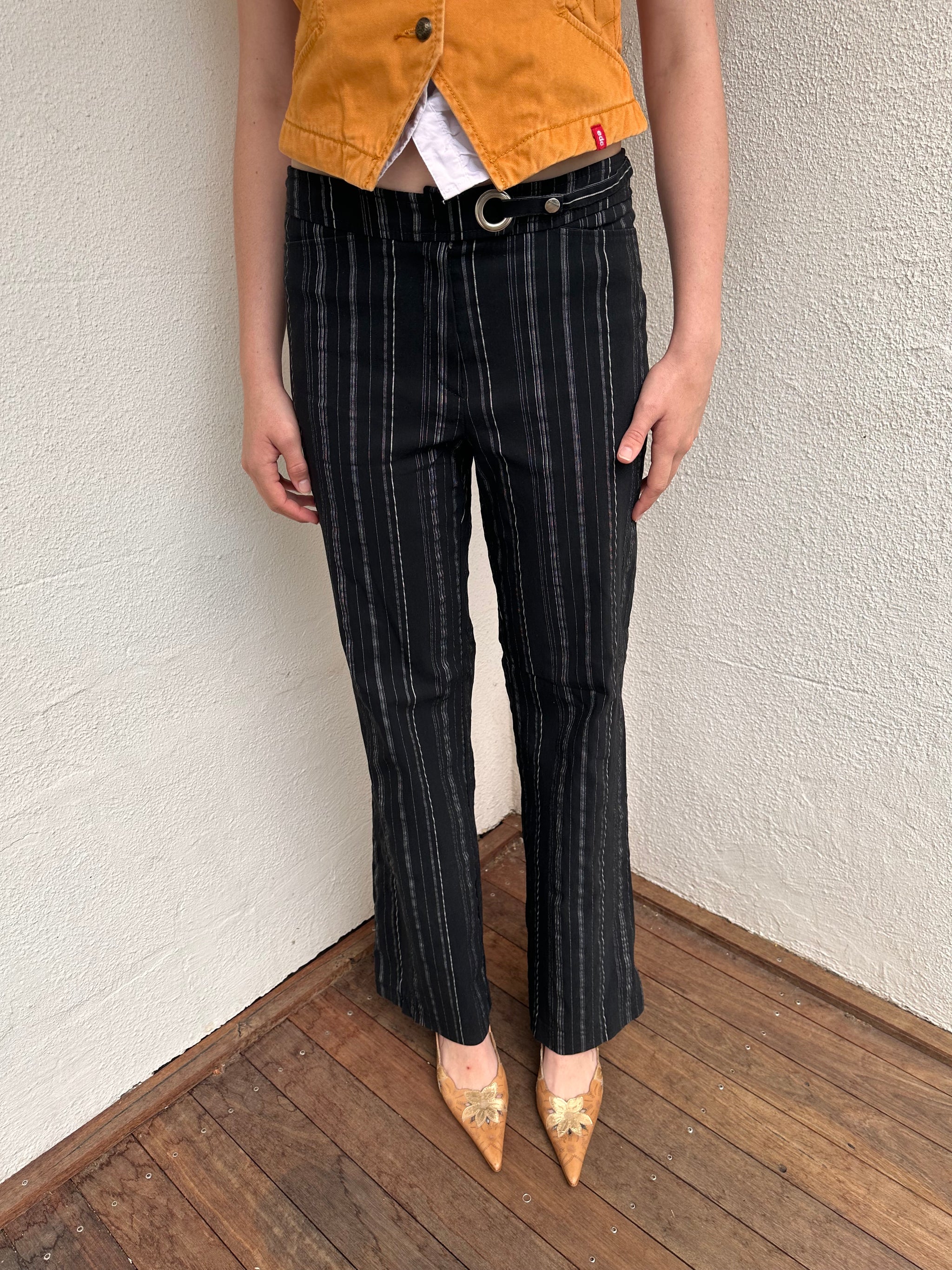 Women wearing a 00s Y2K Black and white pinstripe suit pants with a built-in grommet-look belt and straight-leg cut. 