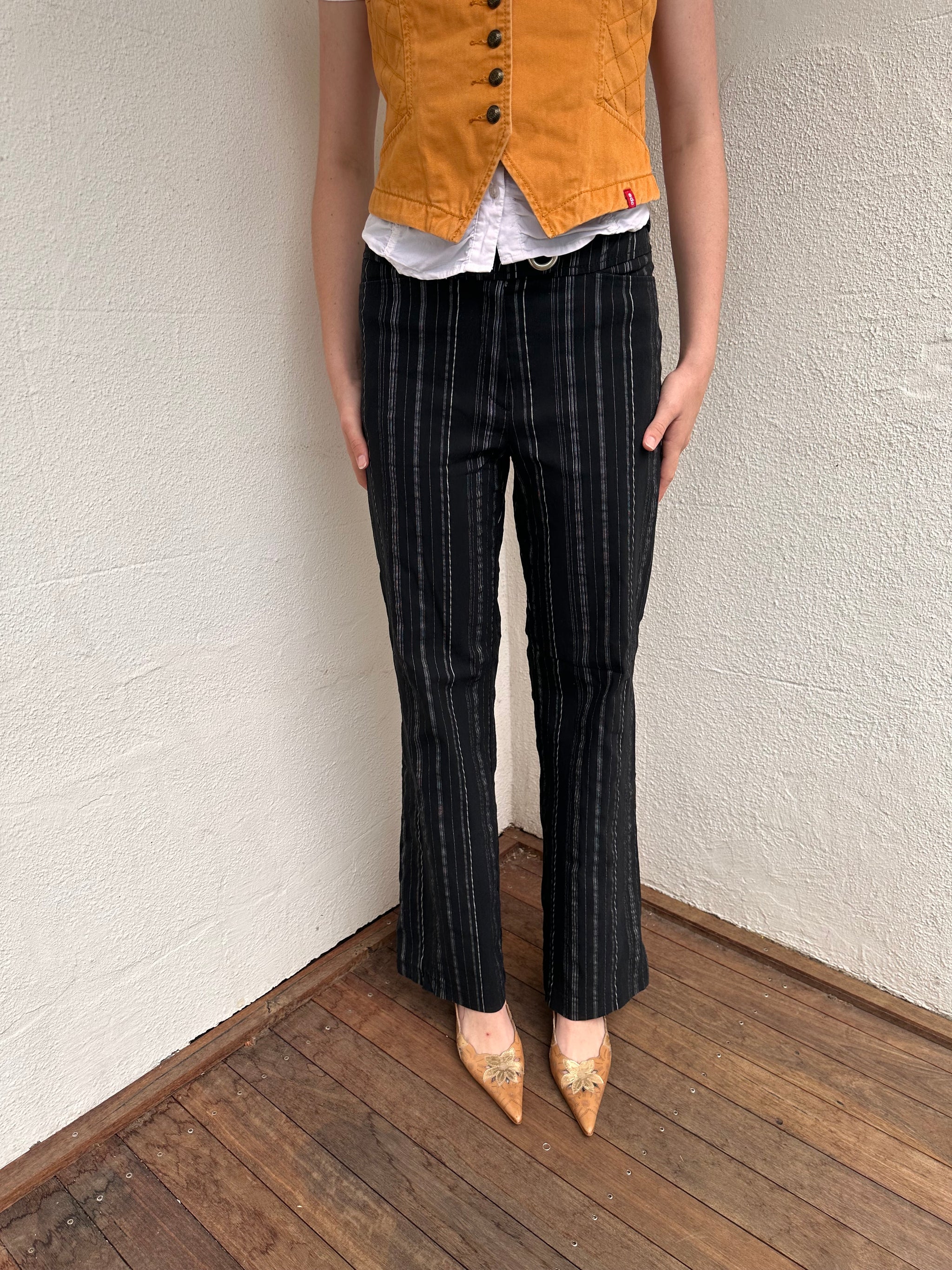 Women wearing a 00s Y2K Black and white pinstripe suit pants with a built-in grommet-look belt and straight-leg cut. 