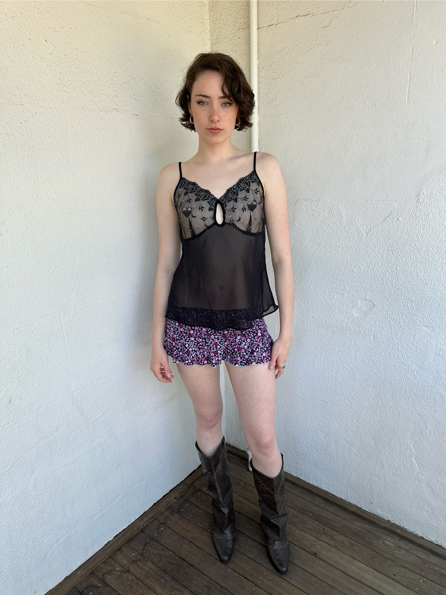 Woman Dressed in Y2K Black and pink floral mini skirt featuring a black base with pink floral detailing throughout. 