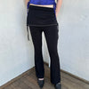 Woman Dressed in Y2K Black rhinestone detail skirt pants featuring a mini skirt attached over flared pants. 