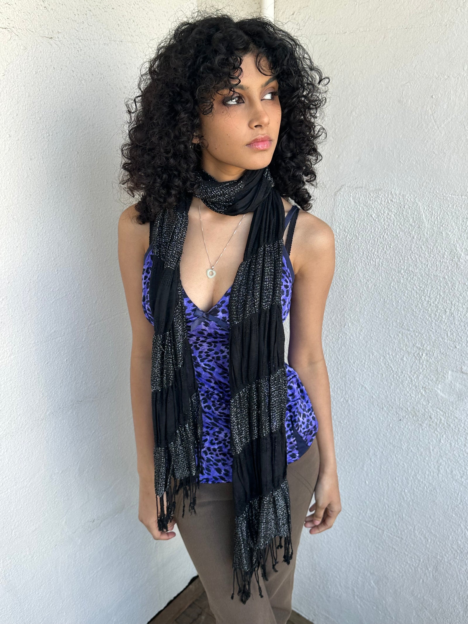 Woman wearing a Y2K 90s Black shimmer stripe scarf from the 00s.