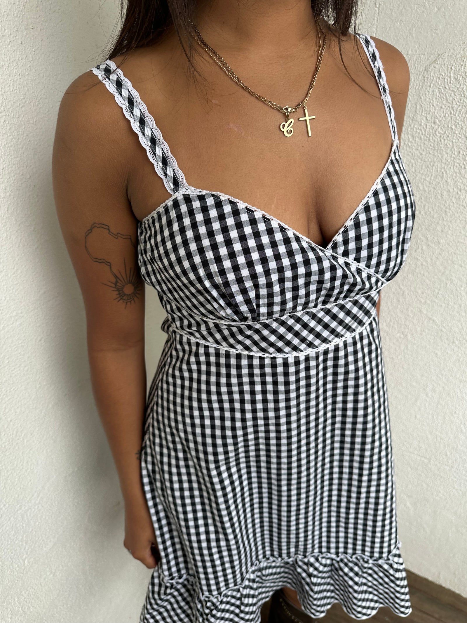 Woman Dressed in Y2K 00s Black and white checkered dress with a fitted bodice, flared skirt, and ruffle hem