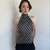 Woman Dressed in Y2K Black and white diamond pattern halter neck top featuring a striking geometric print with a flattering tie-back neckline.