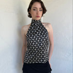Woman Dressed in Y2K Black and white diamond pattern halter neck top featuring a striking geometric print with a flattering tie-back neckline.