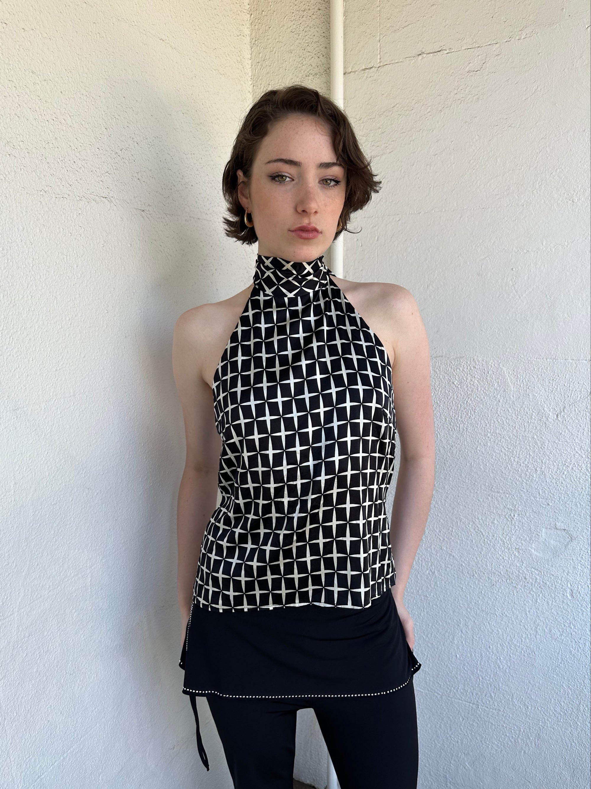 Woman Dressed in Y2K Black and white diamond pattern halter neck top featuring a striking geometric print with a flattering tie-back neckline.