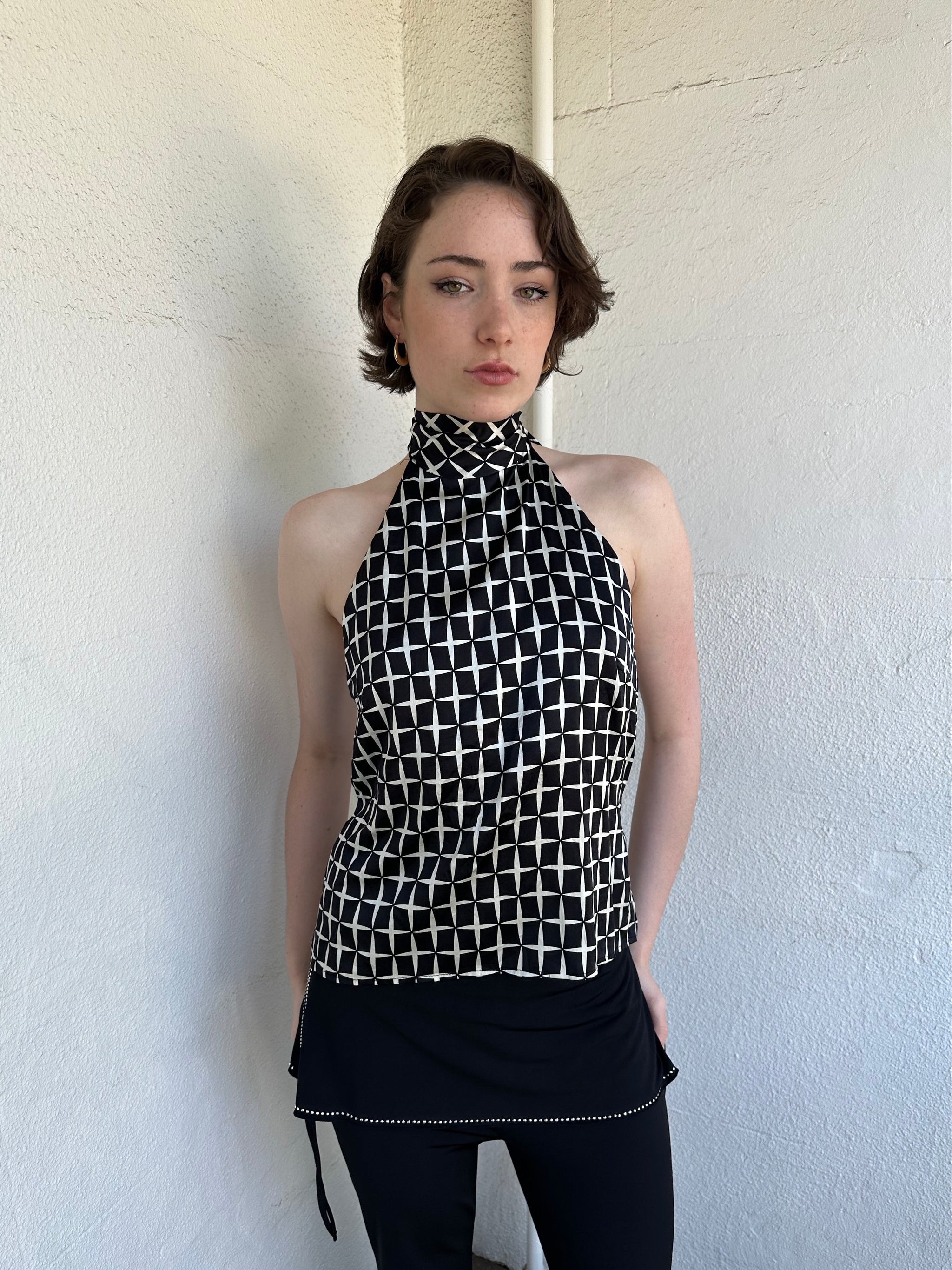 Woman Dressed in Y2K Black and white diamond pattern halter neck top featuring a striking geometric print with a flattering tie-back neckline.